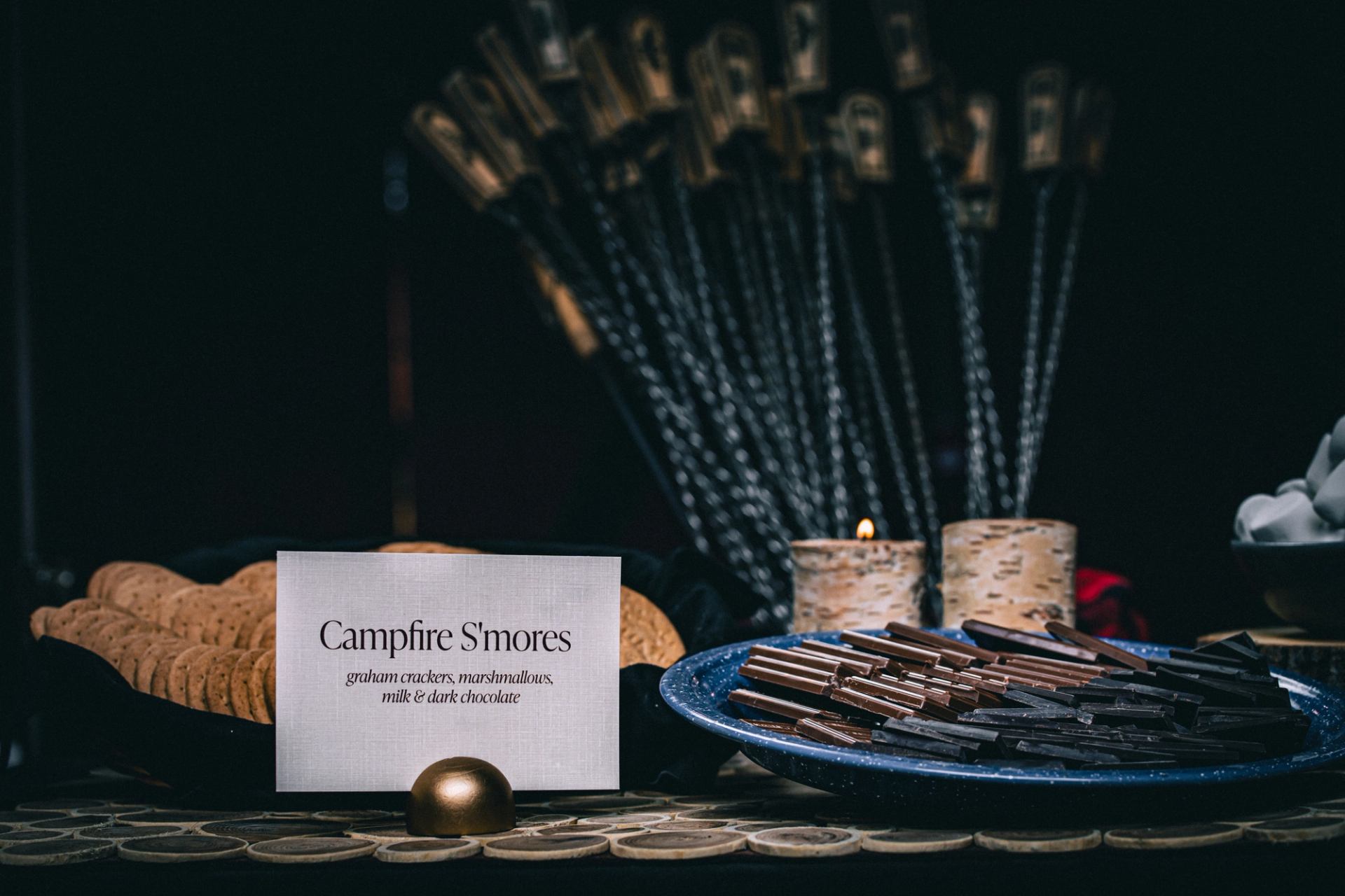 A "Campfire S'mores" station with a sign and candles.