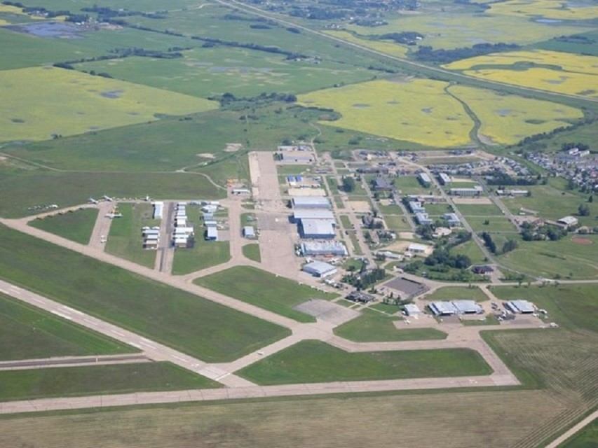 Overhead view of Red Deer Airport showing runways, buildings, and surrounding farmland.