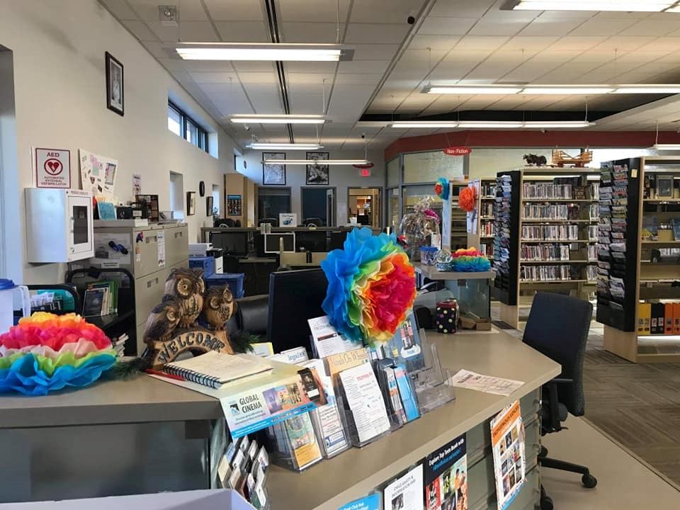 Interior of Wildwood Library showing bookshelves, colorful decor, and service desk.