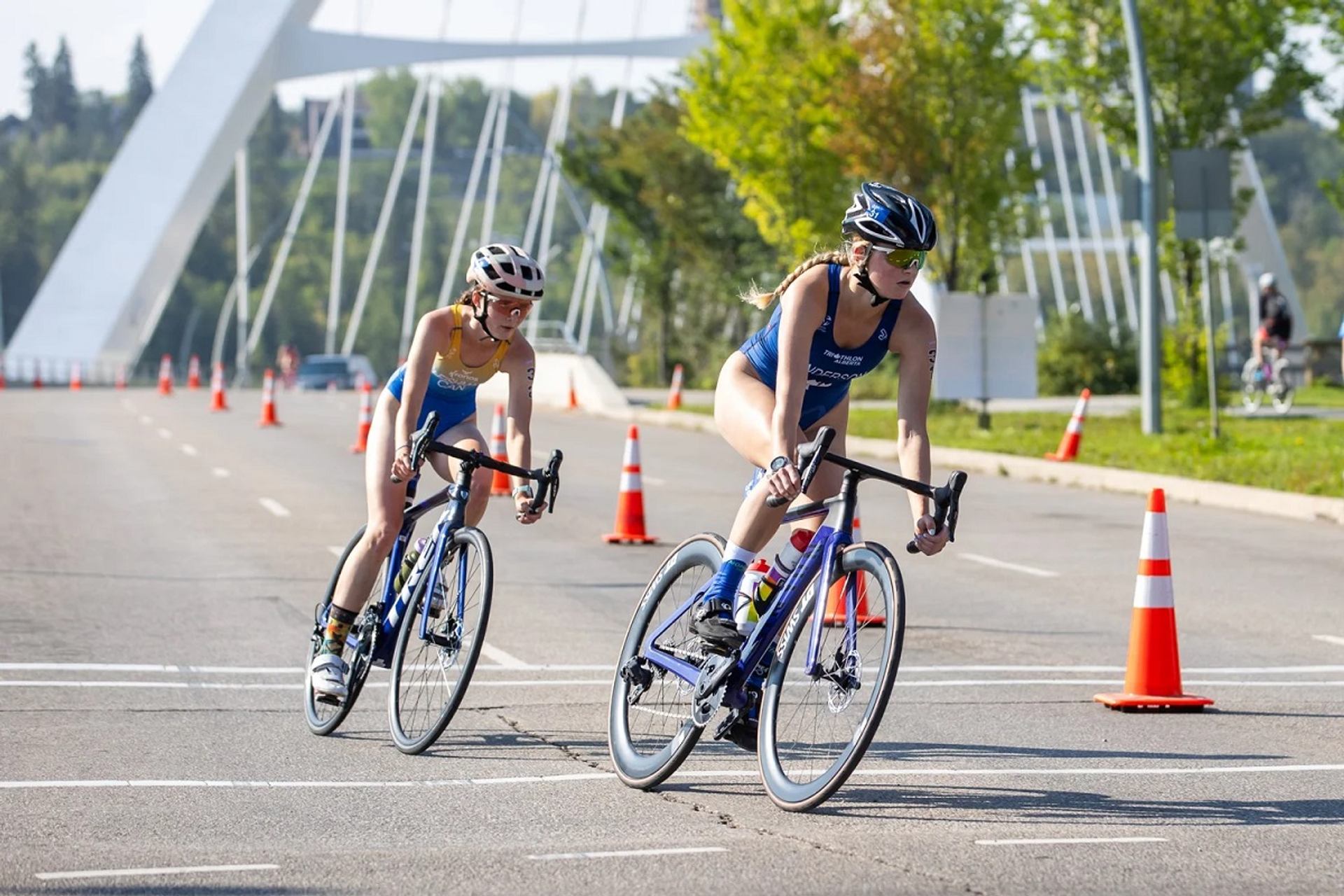 Cyclists race past cones near bridge at Do North Tri & Trail.