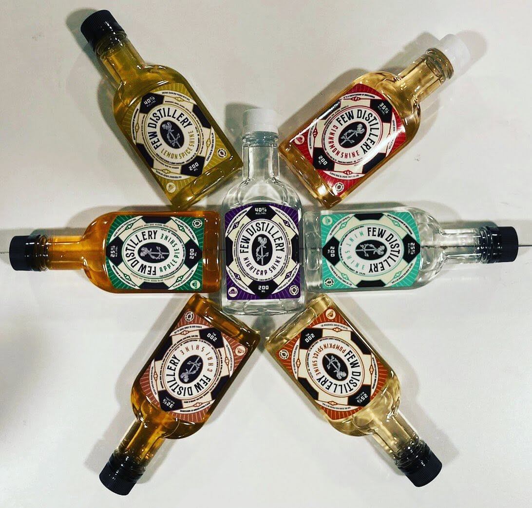 Bottles of handcrafted spirits form a star-shaped arrangement on a white background for display.