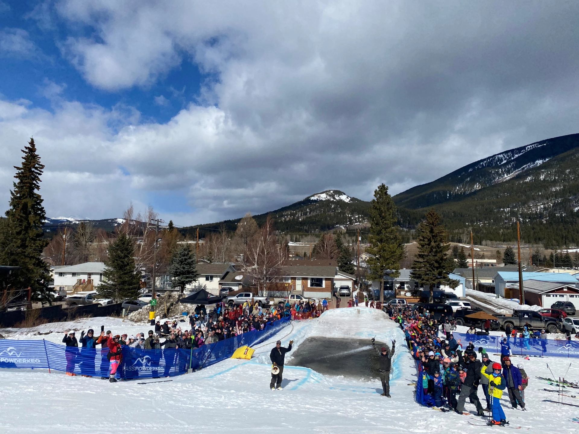 Crowd gathers at snowy slope for Slush Cup festivities.