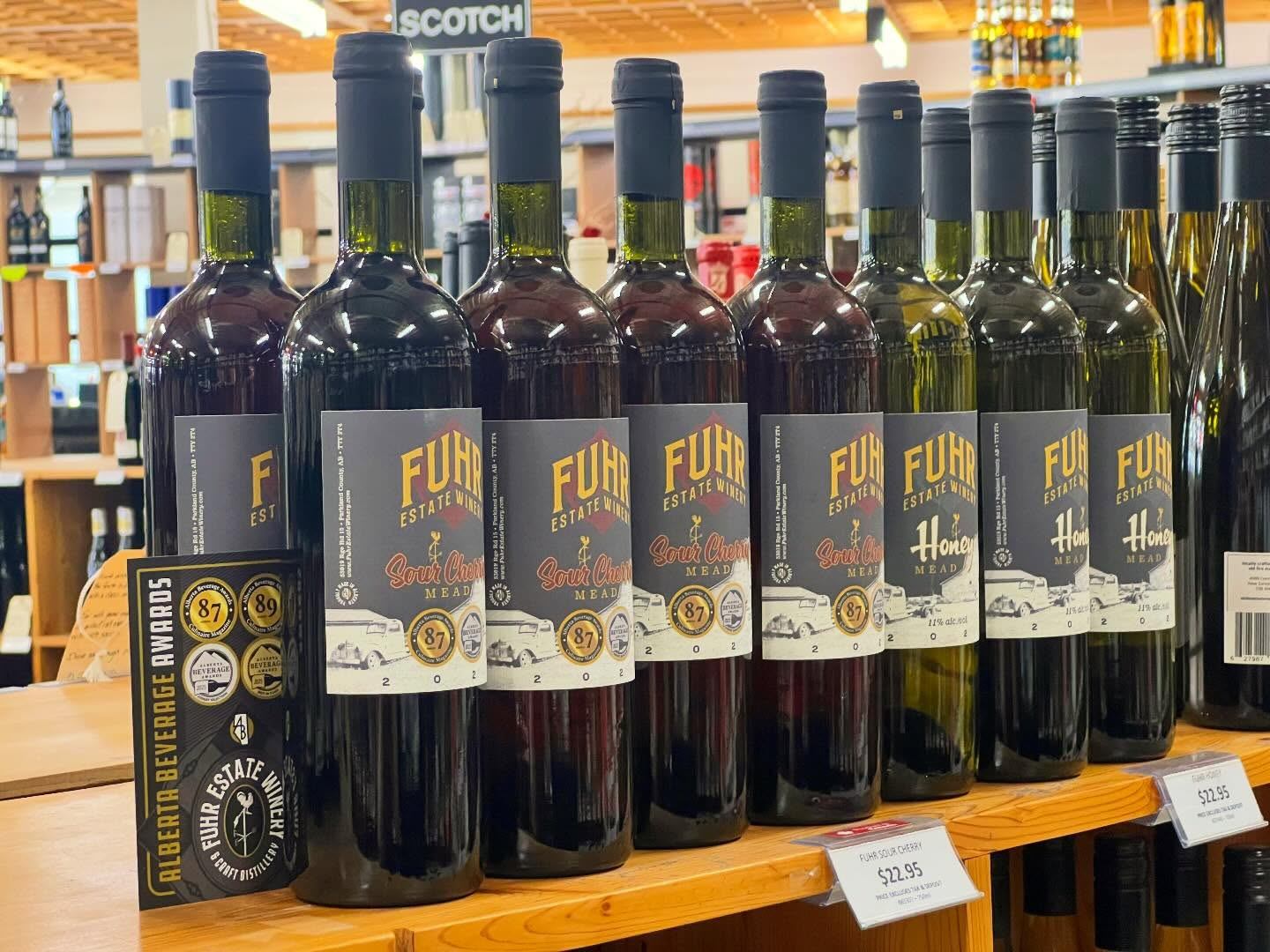 Rows of Fuhr Estate Winery mead bottles are displayed on wooden shelves inside a retail space.