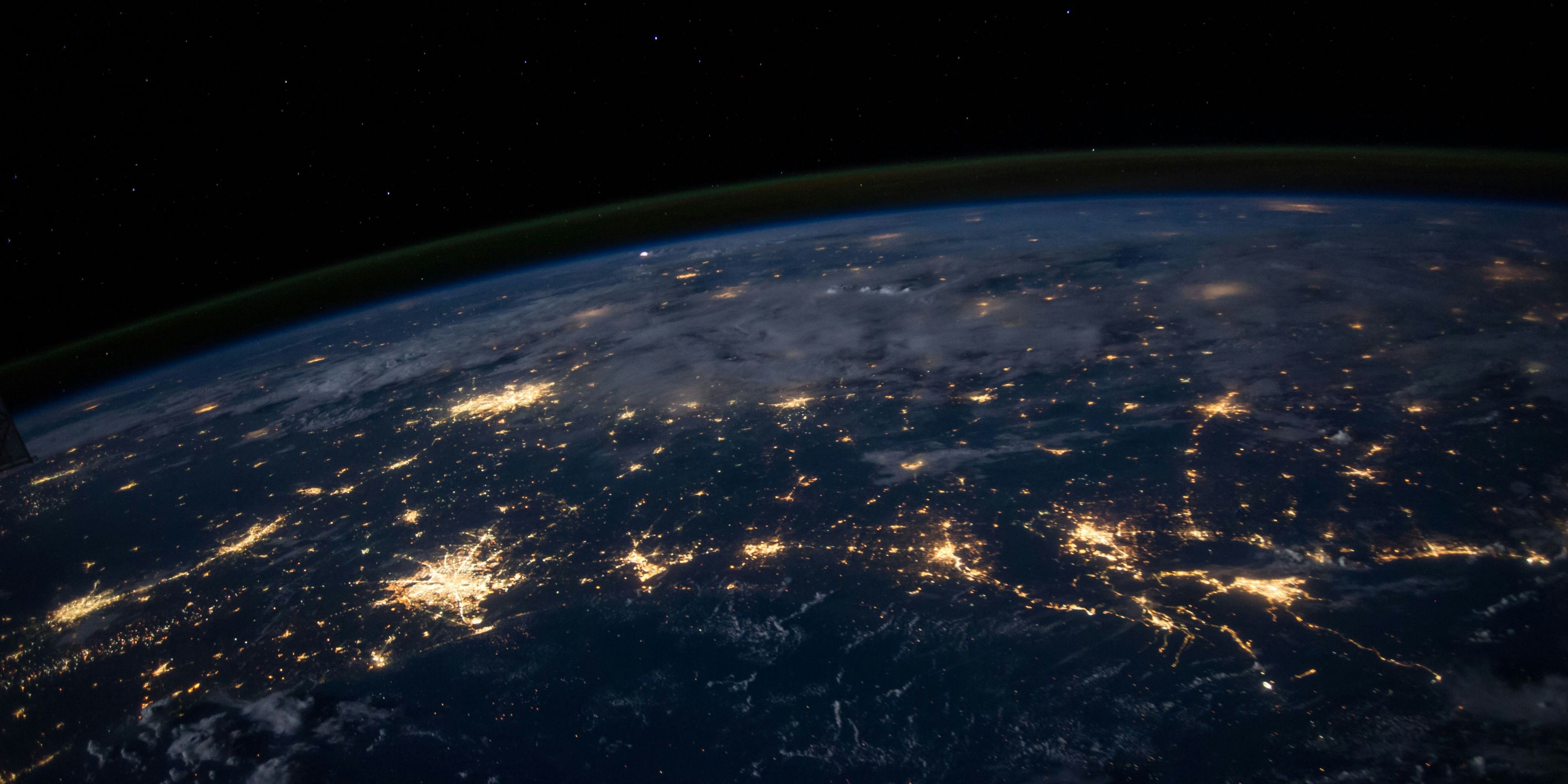 a view of the earth from space at night with cities lit up .