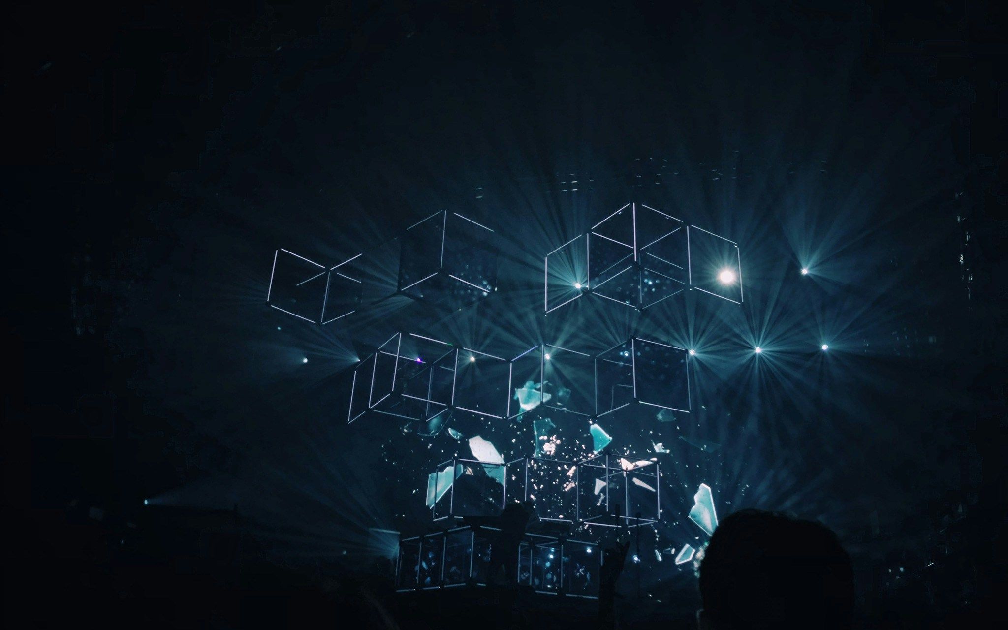 a person is standing in front of a stage with a lot of lights coming out of it .