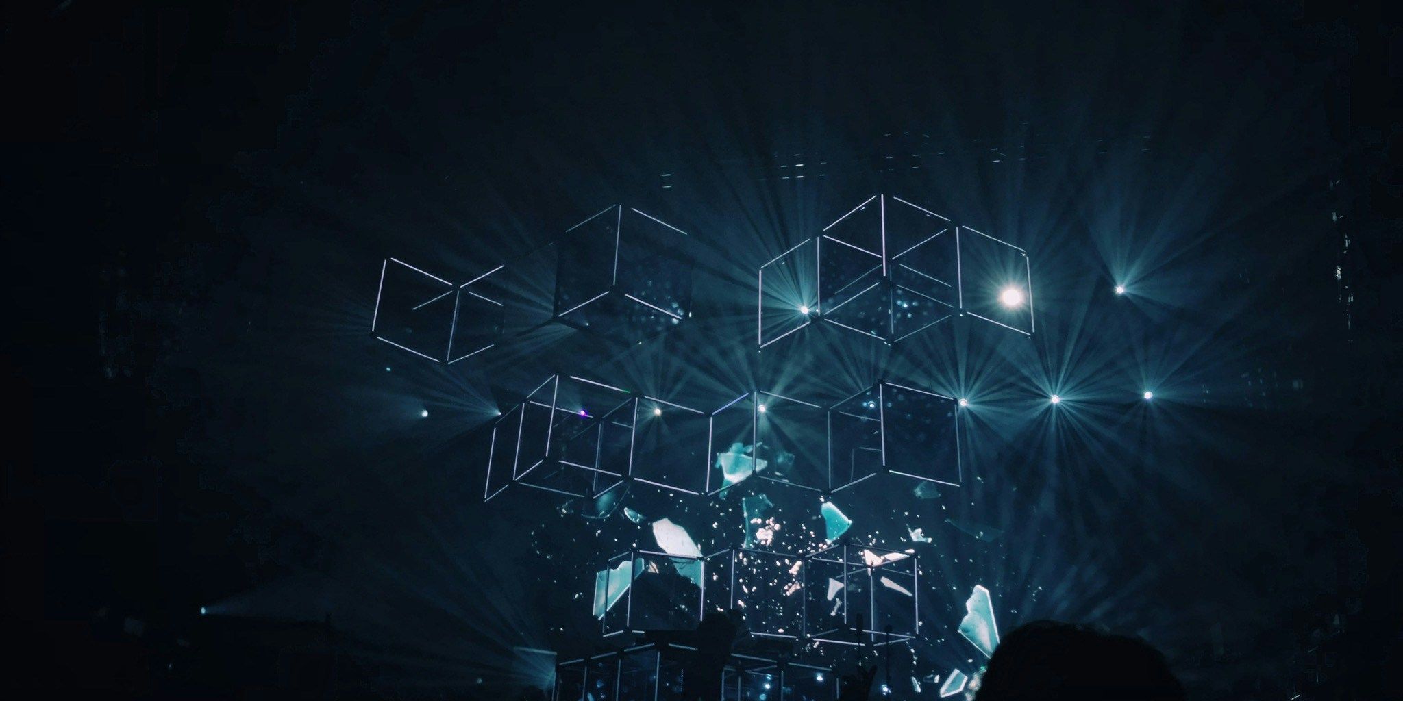 a person is standing in front of a stage with a lot of lights coming out of it .