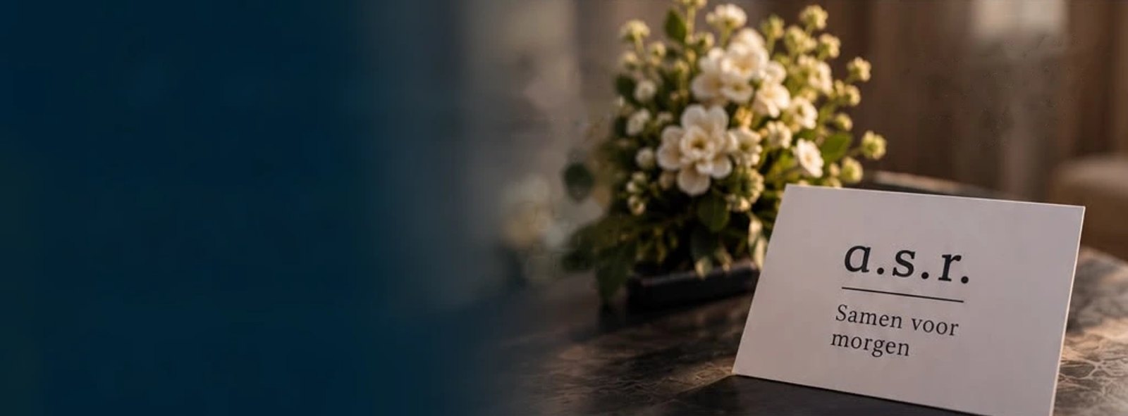 Witte bloemen op een tafel, met een kaartje van ASR