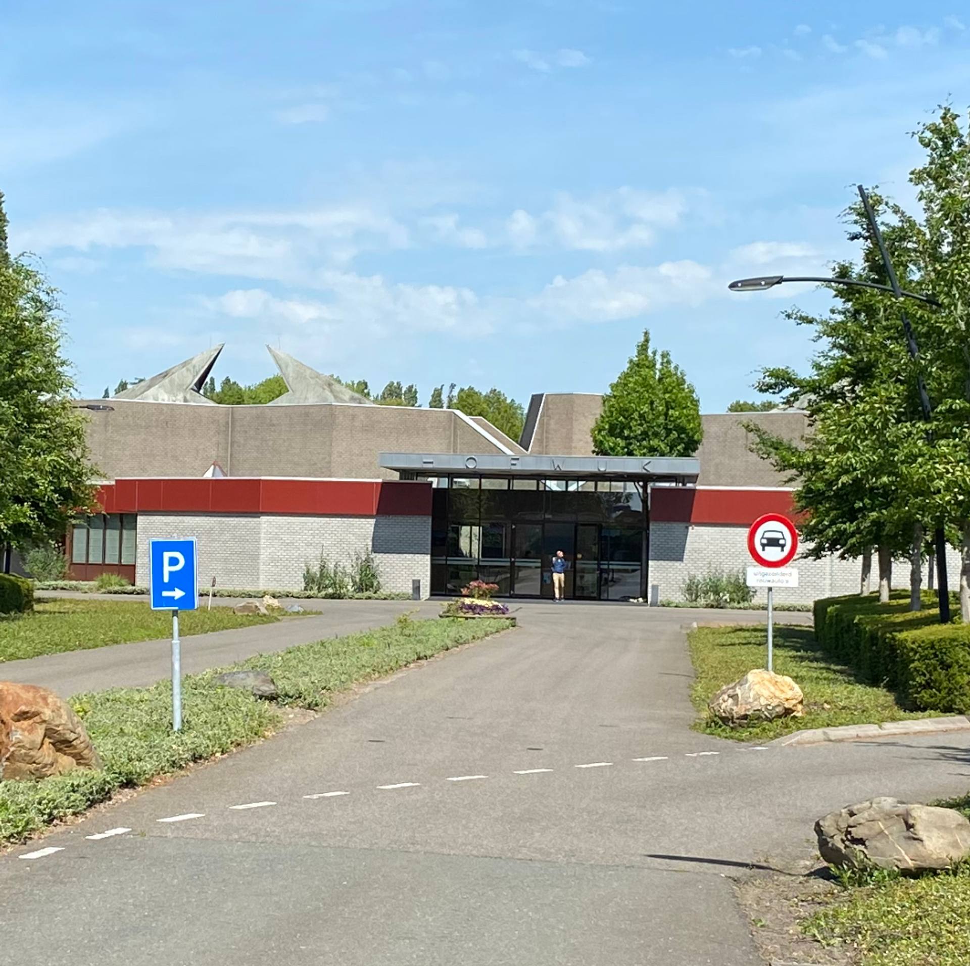 De oprit naar Hofwijk in Rotterdam, met het gebouw achter de bomen