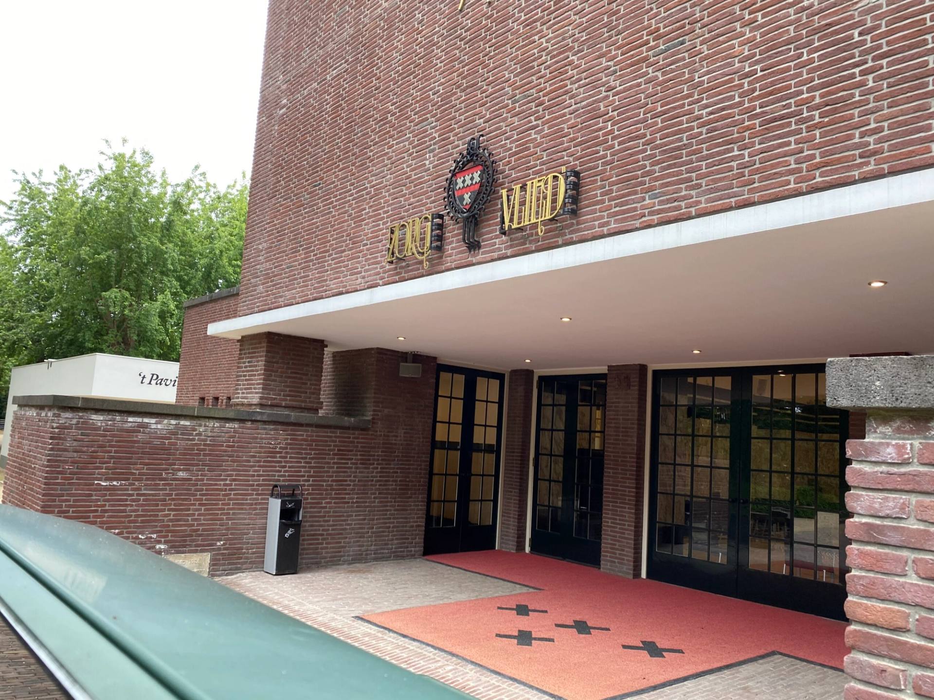 De bakstenen entree van Zorgvlied aan de Amsteldijk, met de naam boven de deuren