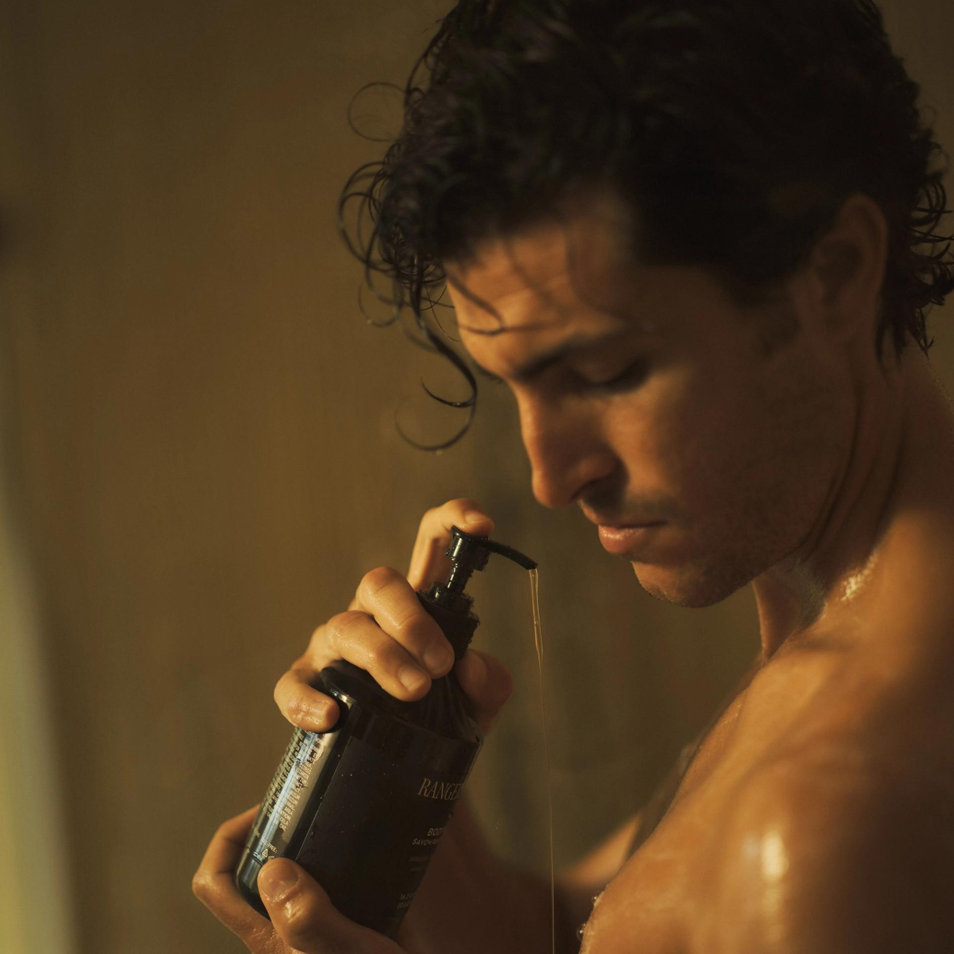 Man in shower using Ranger Station Santalum Body Wash on body