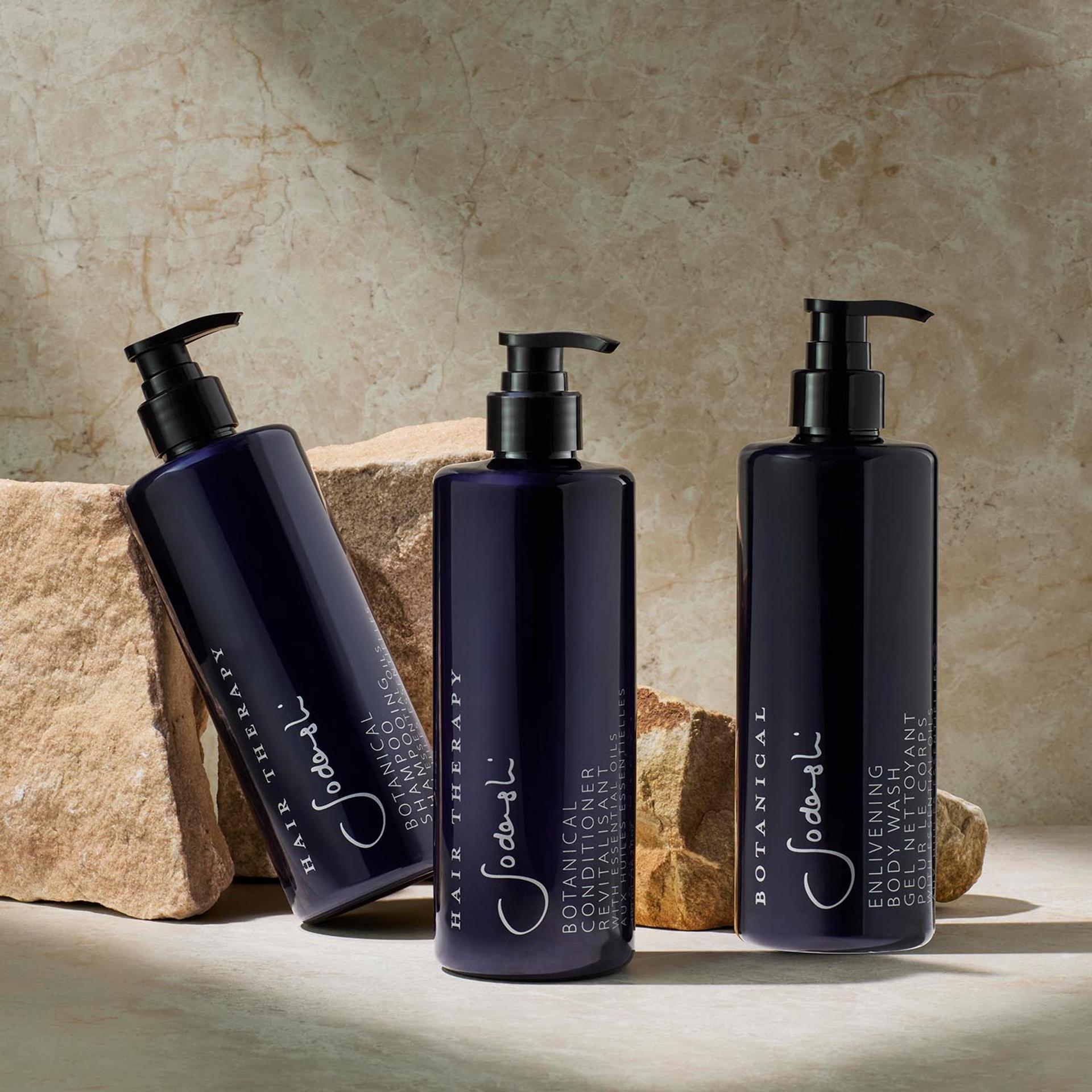 Sodashi Shampoo, Conditioner, and Body Wash dispensers on bathroom vanity with rocks