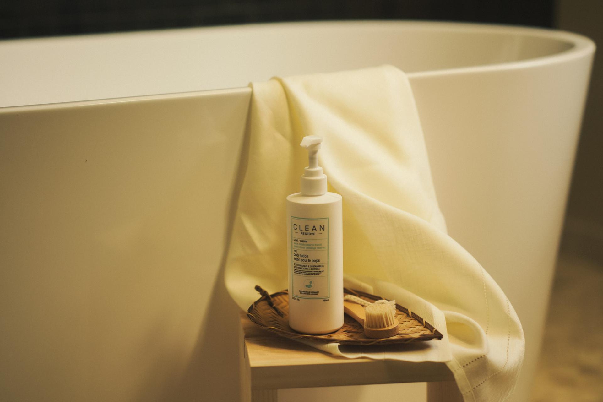 Clean Reserve Body Lotion bottle in bathroom next to bathtub