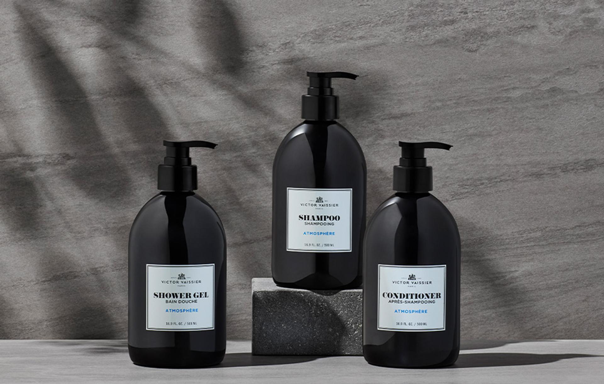 Victor Vaissier Shampoo, Conditioner, and Body Wash dispensers on bathroom vanity with stone
