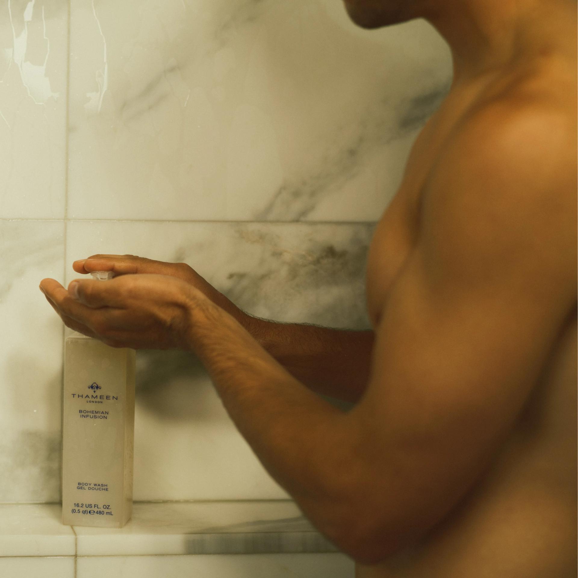 Man in shower using Thameen London Bohemian Infusion Body Wash dispenser