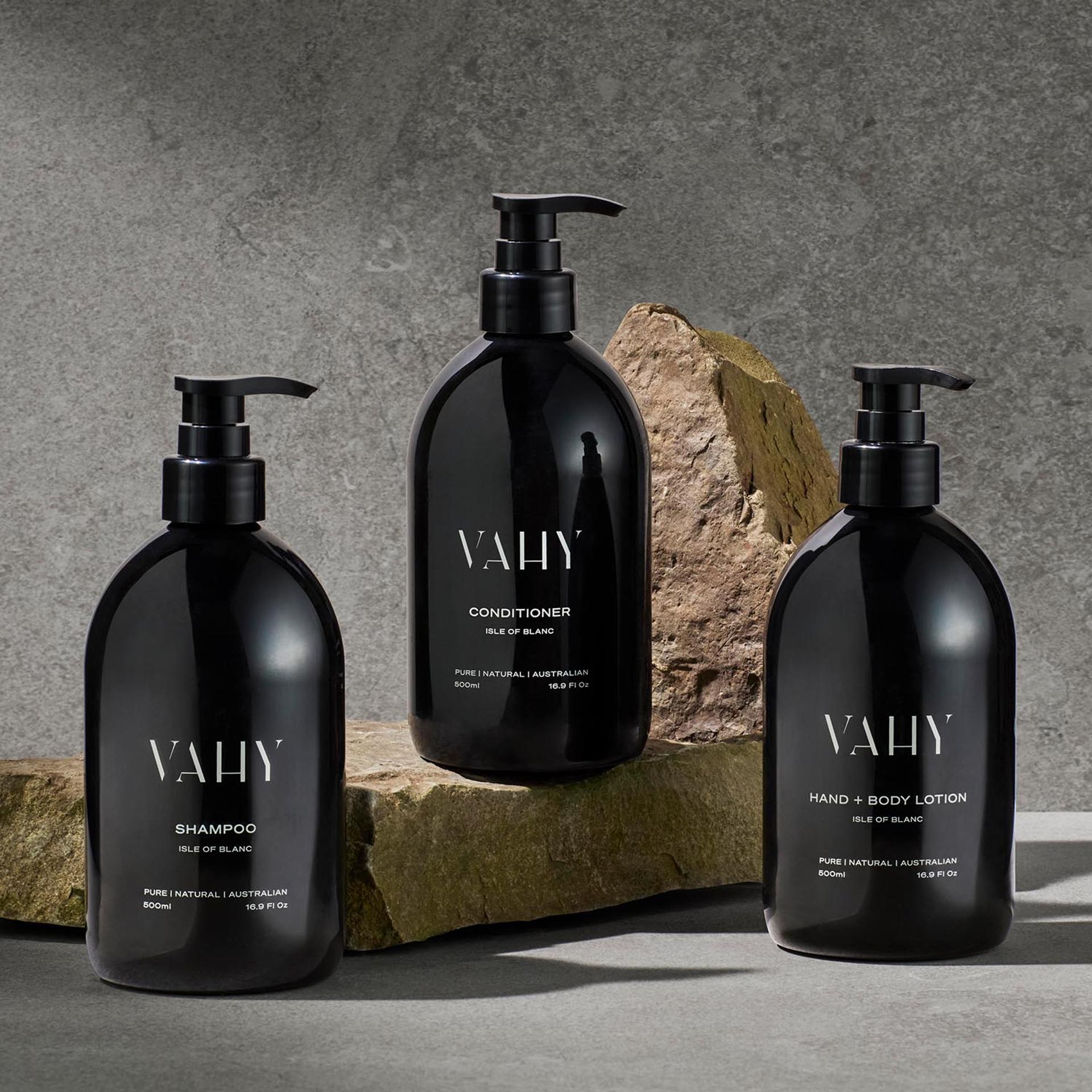 Vahy Isle of Blance Shampoo, Conditioner, and Body Lotion dispensers on stone bathroom vanity
