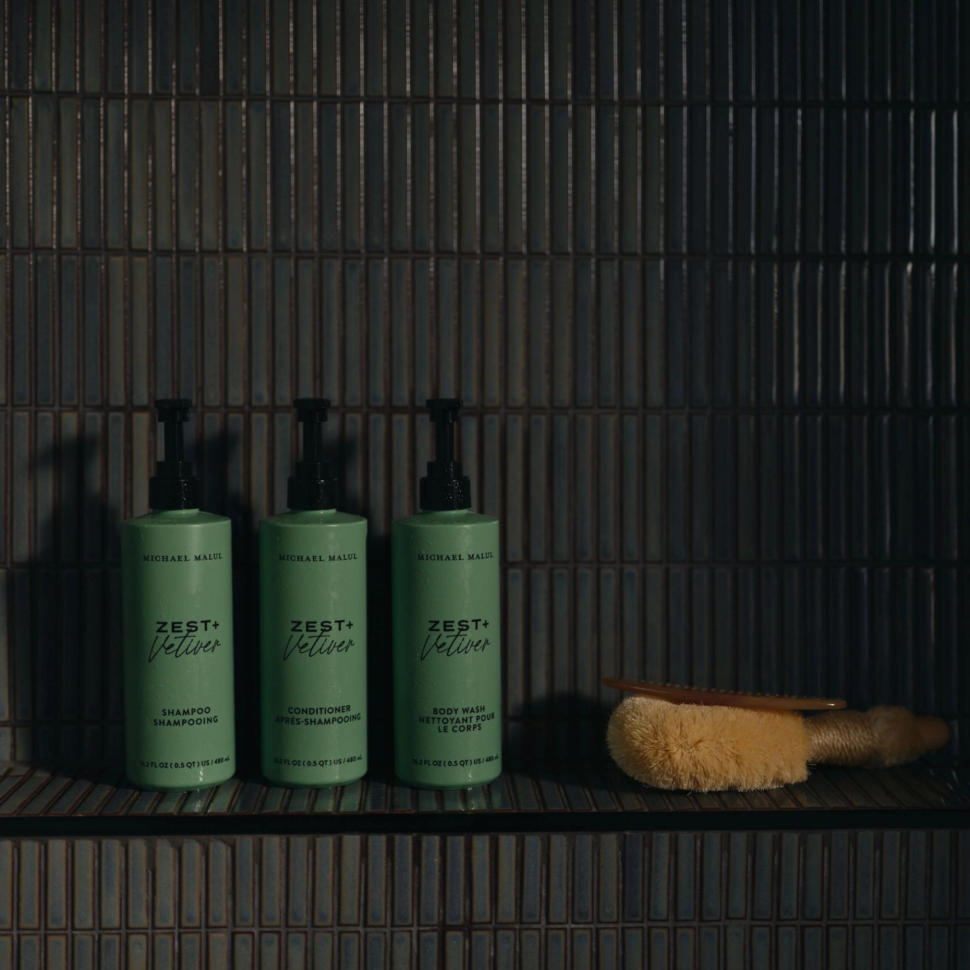 Michael Malul Shampoo, Conditioner, Body Wash 480ml dispensers in the shower.