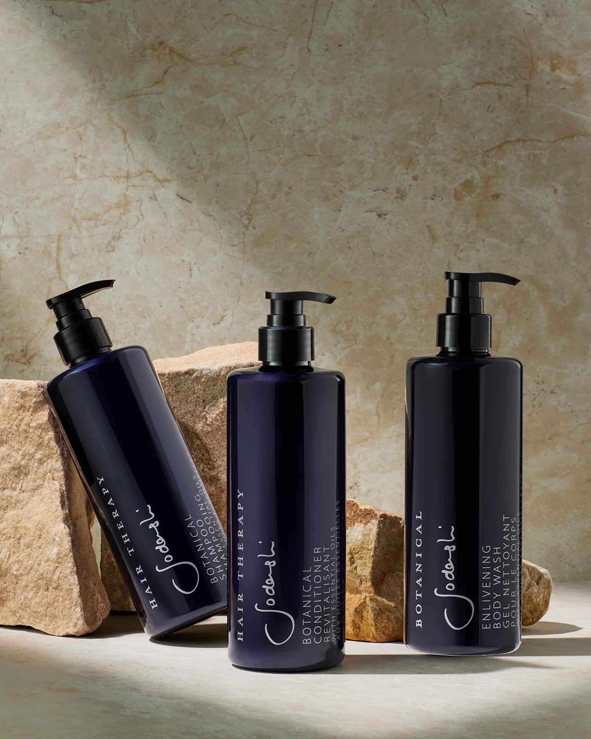 Sodashi Shampoo, Conditioner, and Body Wash dispensers on bathroom vanity with rocks