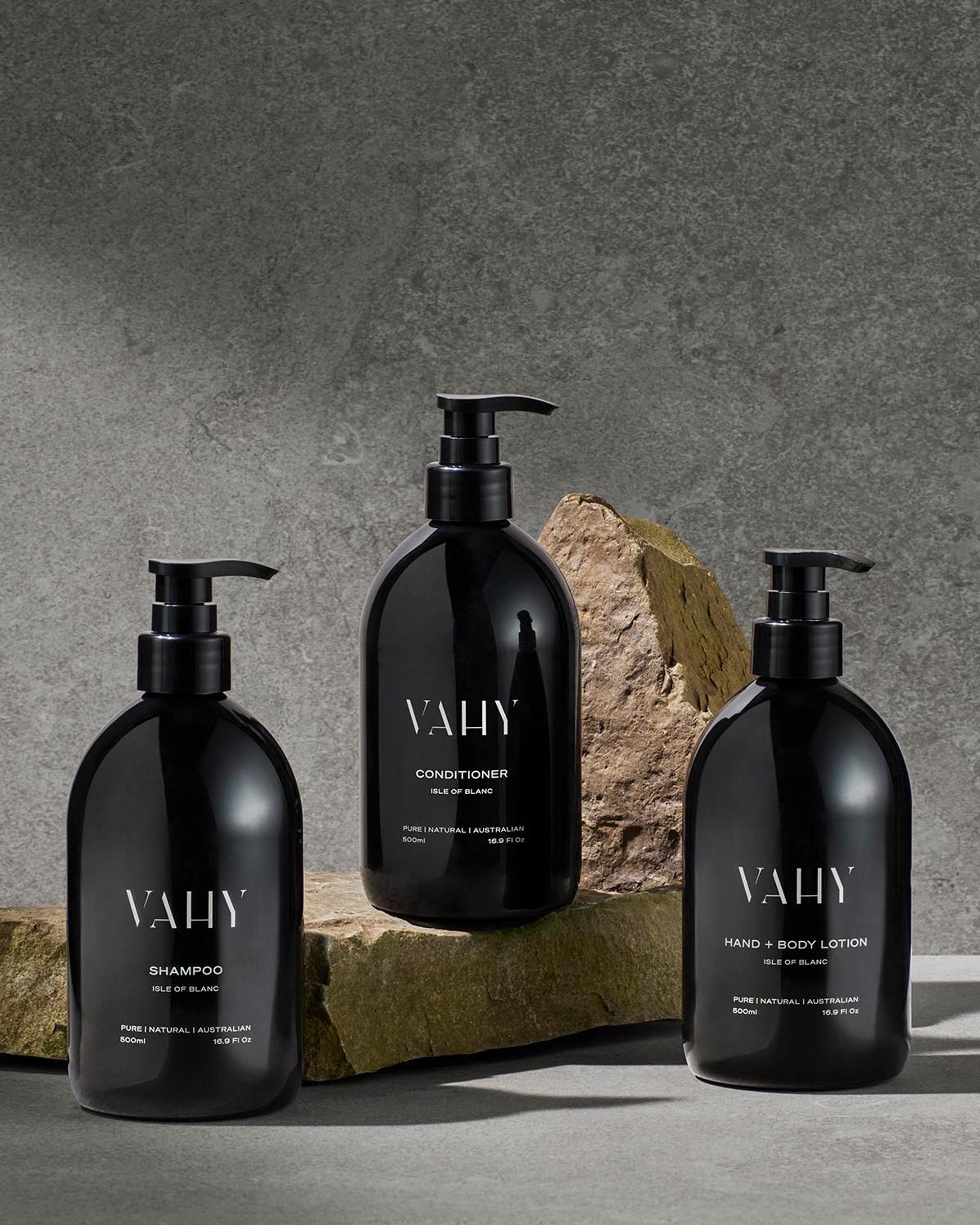 Vahy Isle of Blance Shampoo, Conditioner, and Body Lotion dispensers on stone bathroom vanity