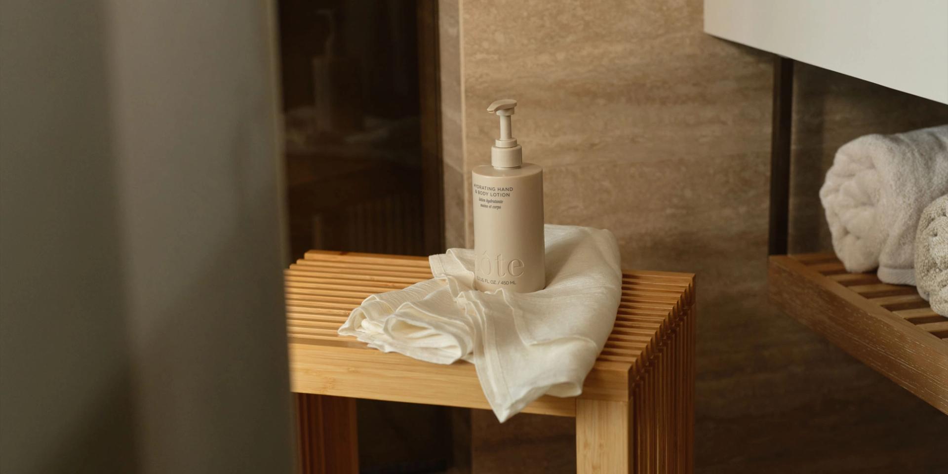 Cote Body Lotion on a wooden bench in the bathroom.