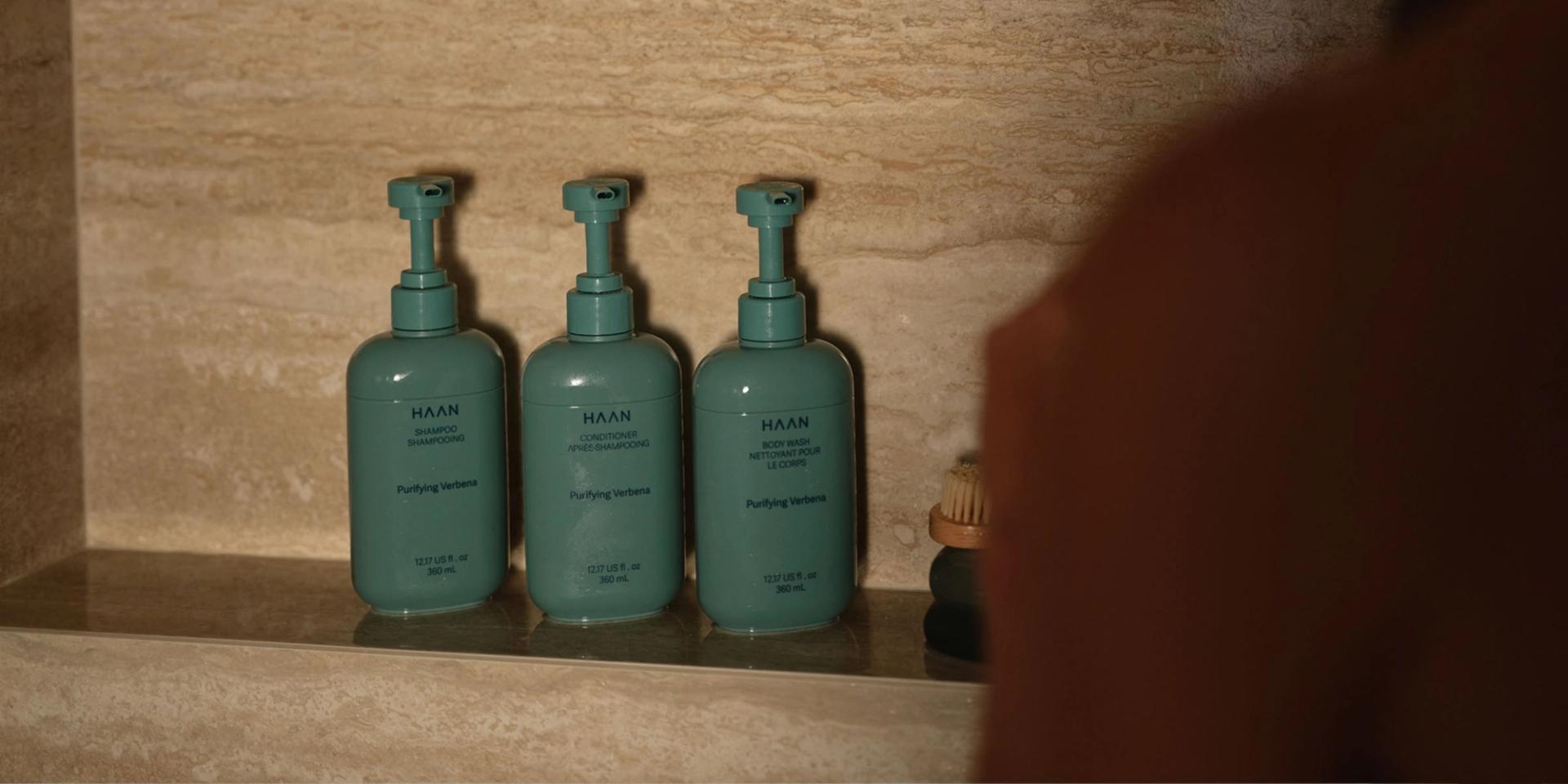 Haan Shampoo, Conditioner, Body Wash in the shower.