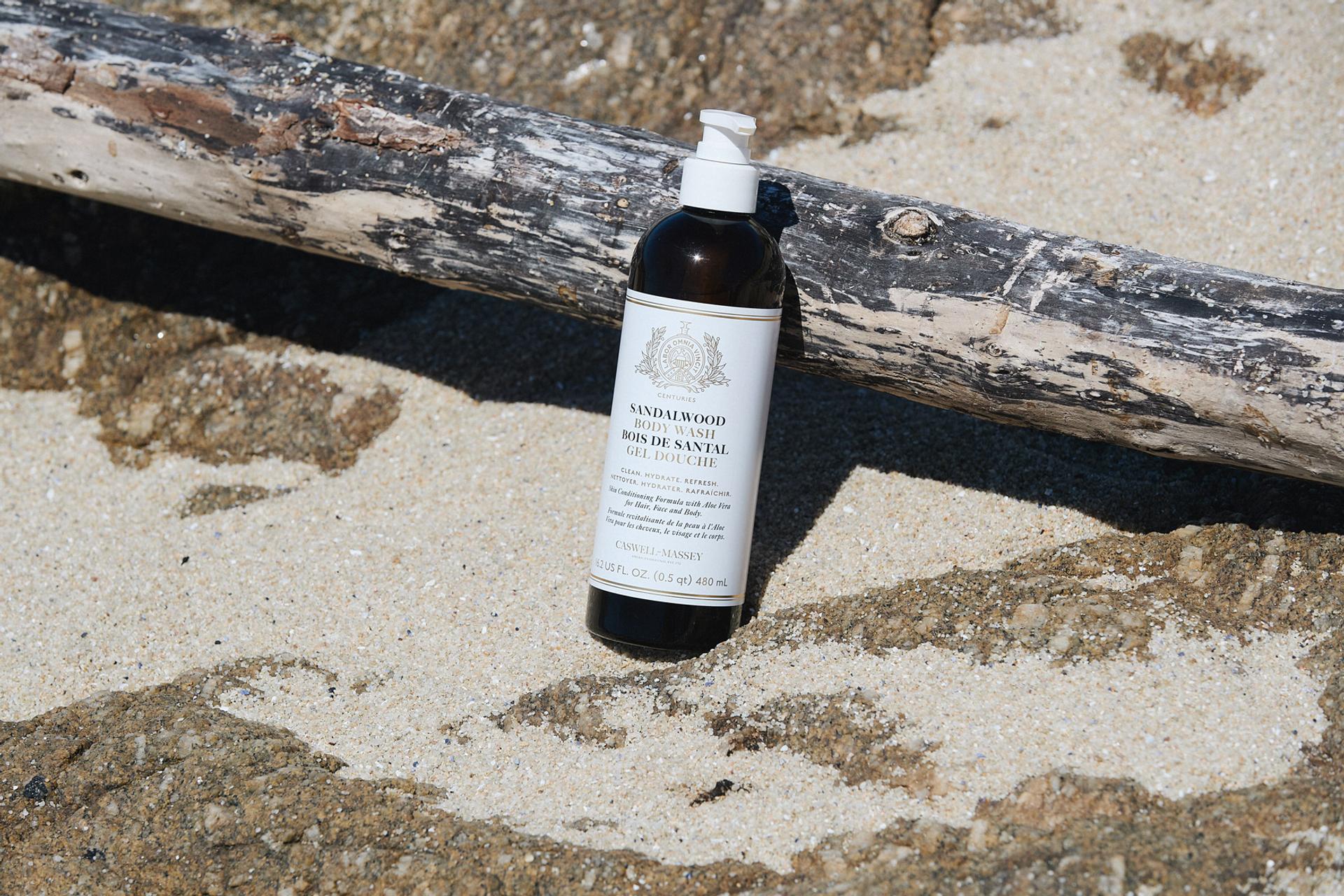 Caswell-Massey Sandalwood Body Wash sitting in sand outdoors