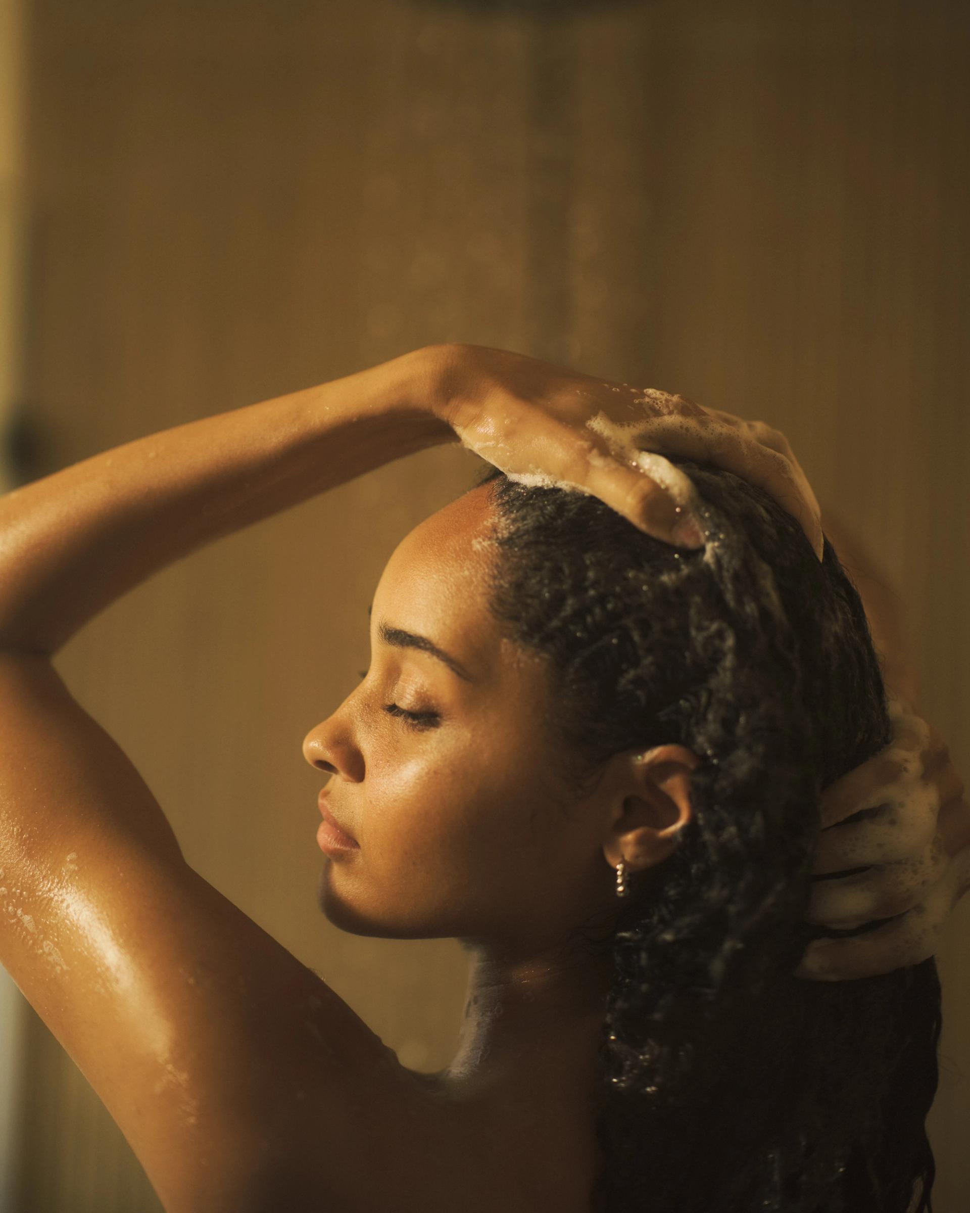 Girl lathering hair in shower