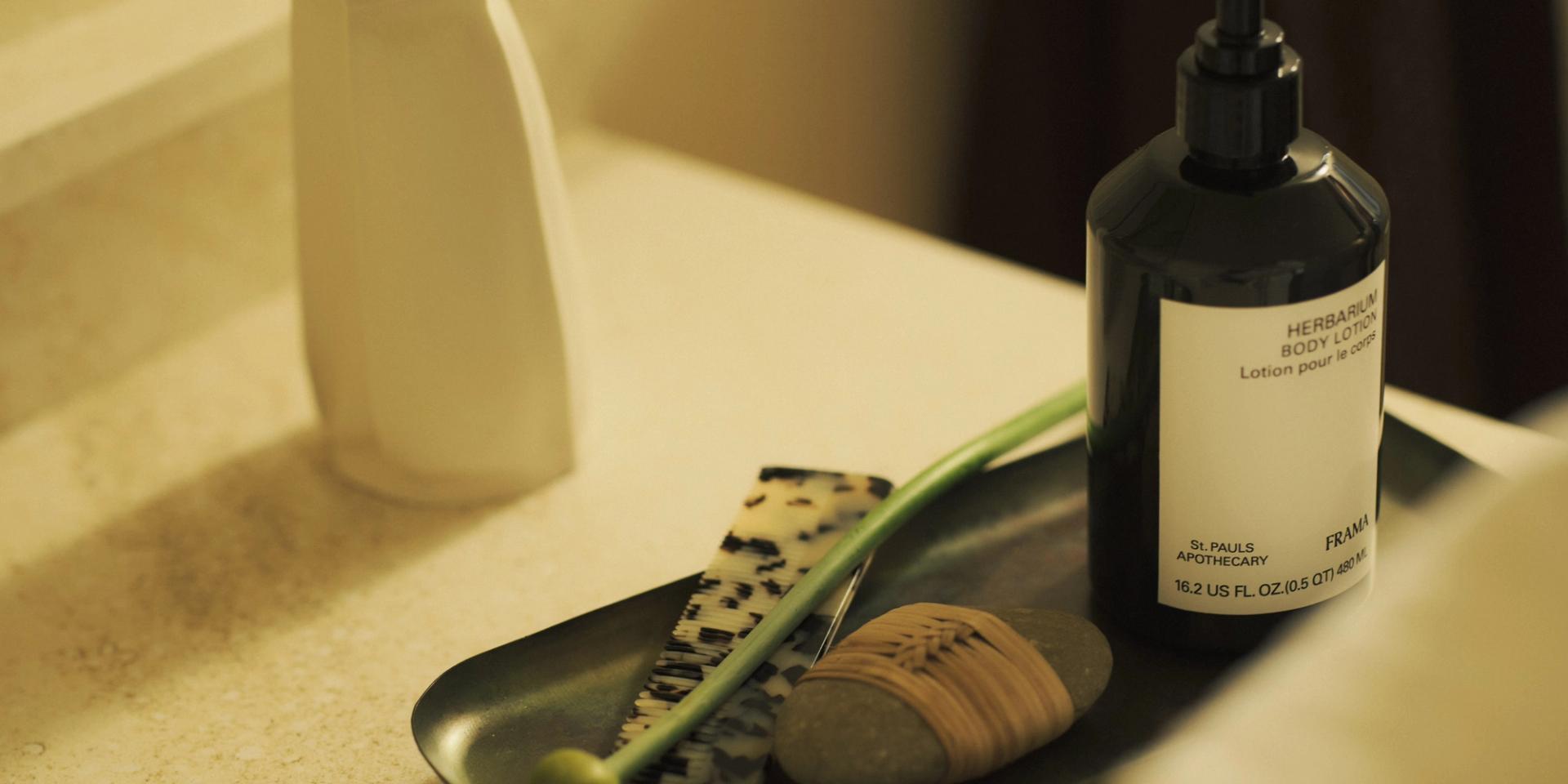 Frama Herbarium Body Lotion sitting on tray on bathroom Countertop
