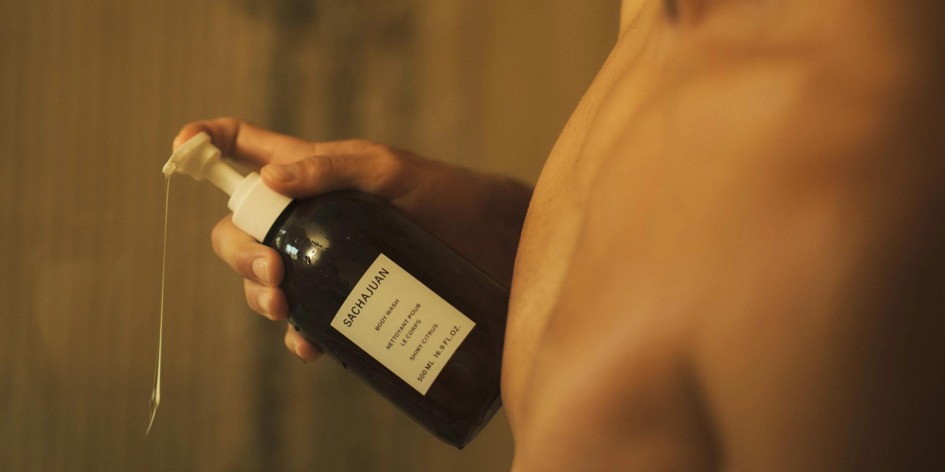 Man in shower using Sachajuan Body Wash dispenser