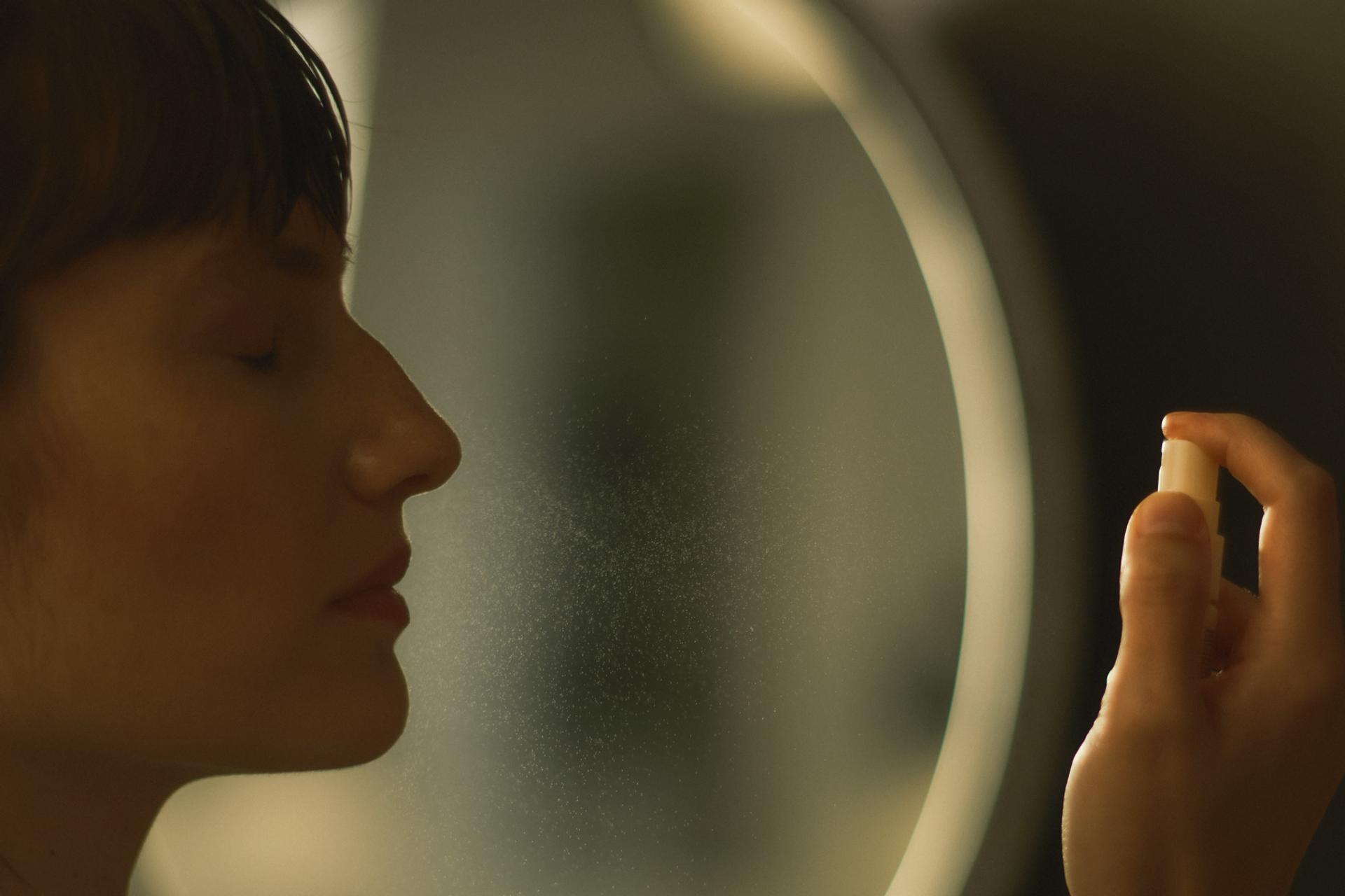 Woman in bathroom spraying Le Labo Basil Face Mist onto face