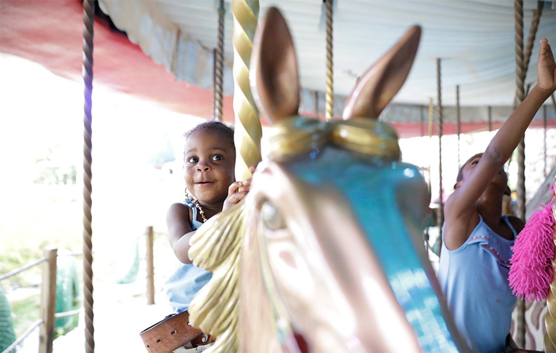 Give Kids the World Village child on merry go round