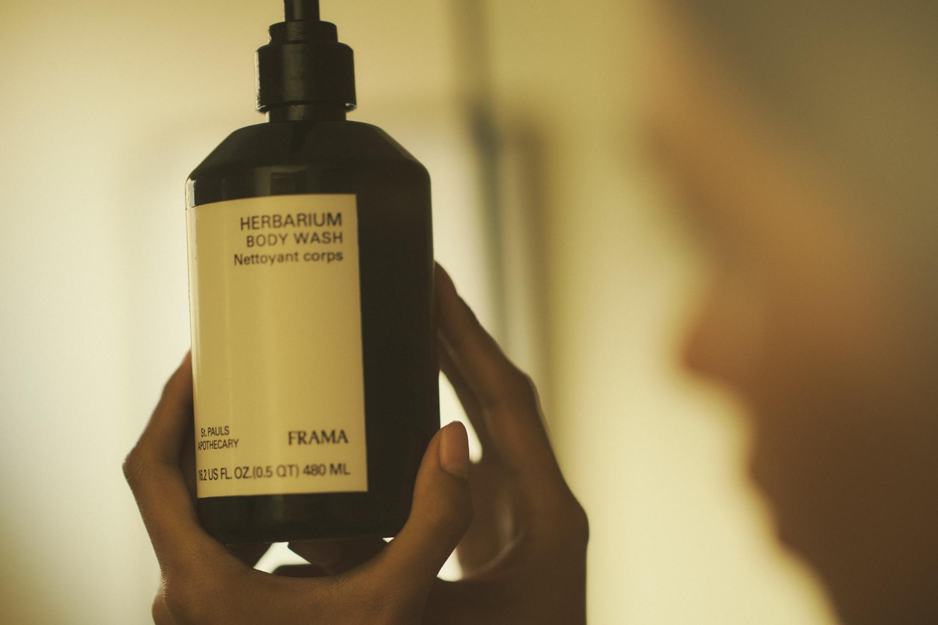 Girl looking at a bottle of Frama Herbarium Body Wash