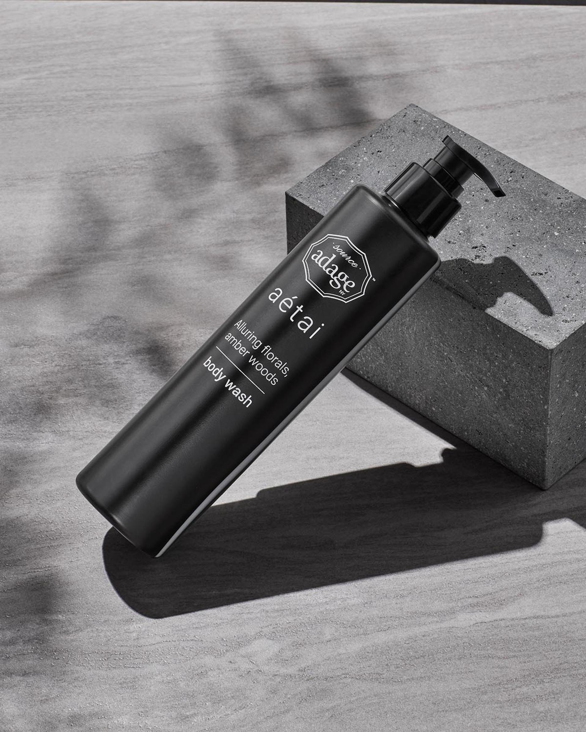 Source Adage Aetai Body Wash dispenser laying against stone