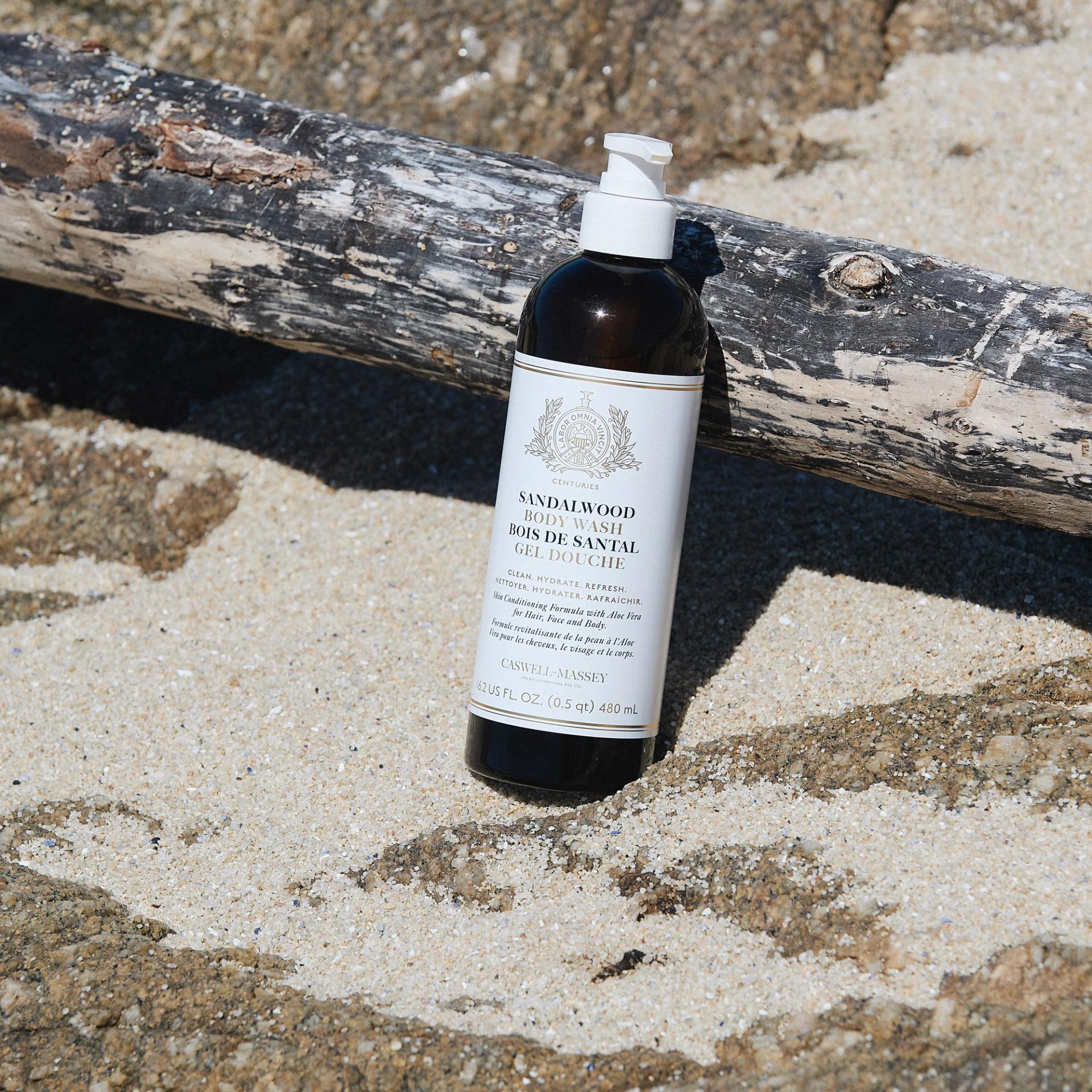 Caswell-Massey Sandalwood Body Wash sitting in sand outdoors