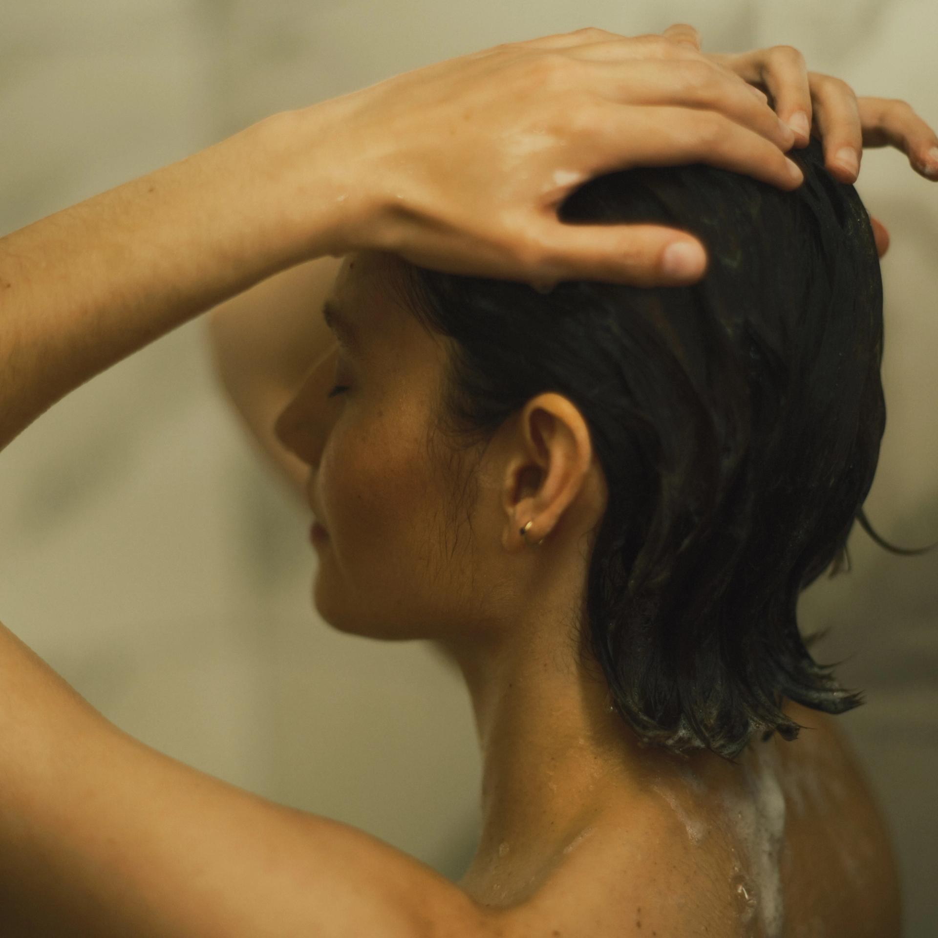 Girl in shower lathering hair