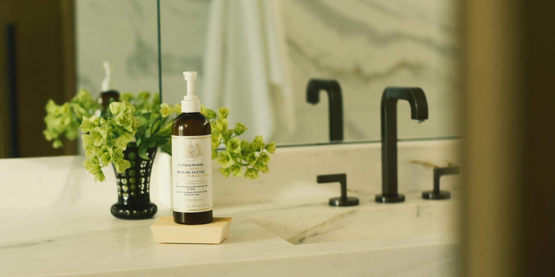 Bottle of Caswell-Massey Sandalwood Body Lotion sitting on bathroom countertop