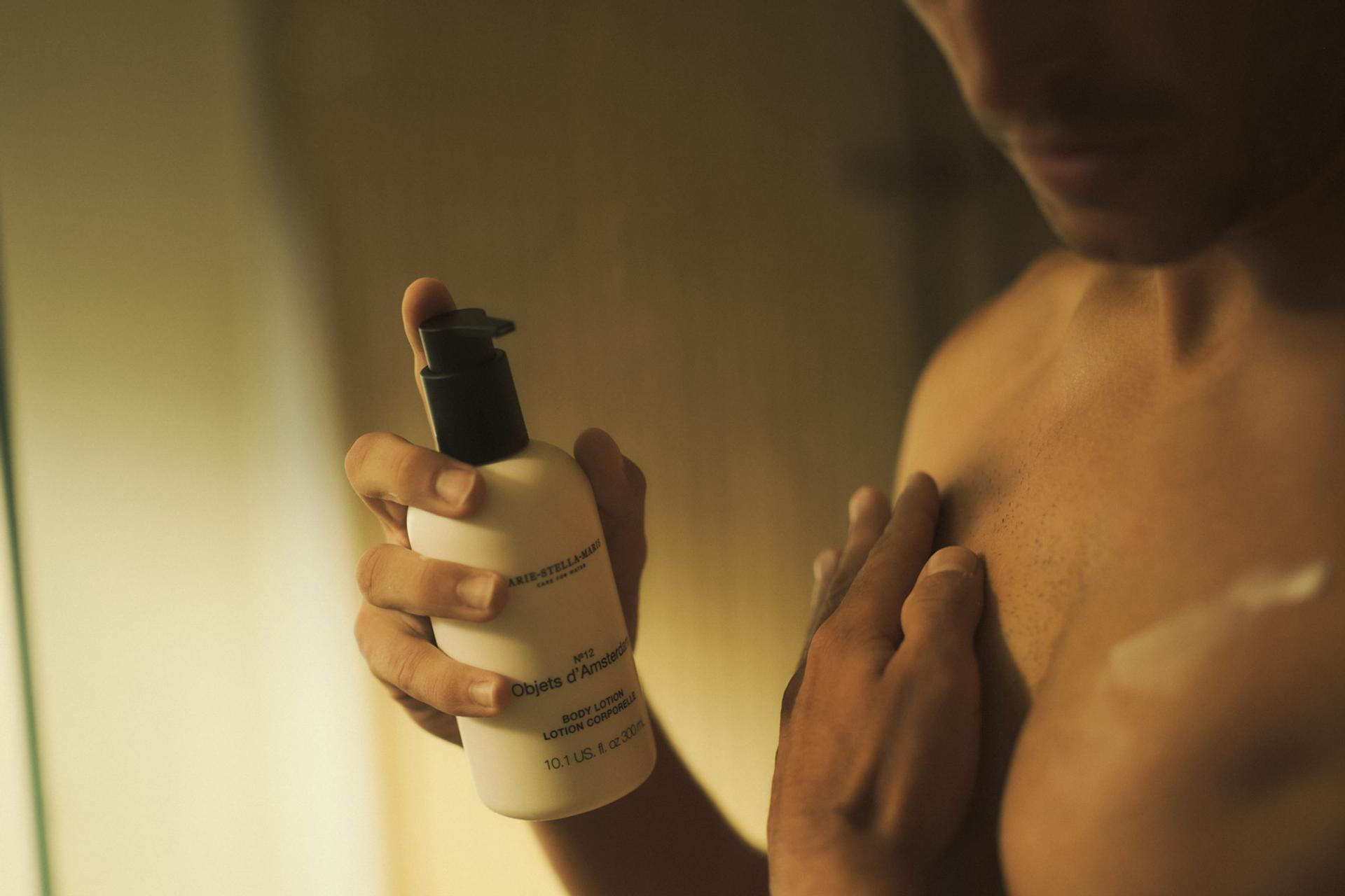 Man in shower applying Marie Stella Maris Objets d'Amsterdam Body Lotion on body