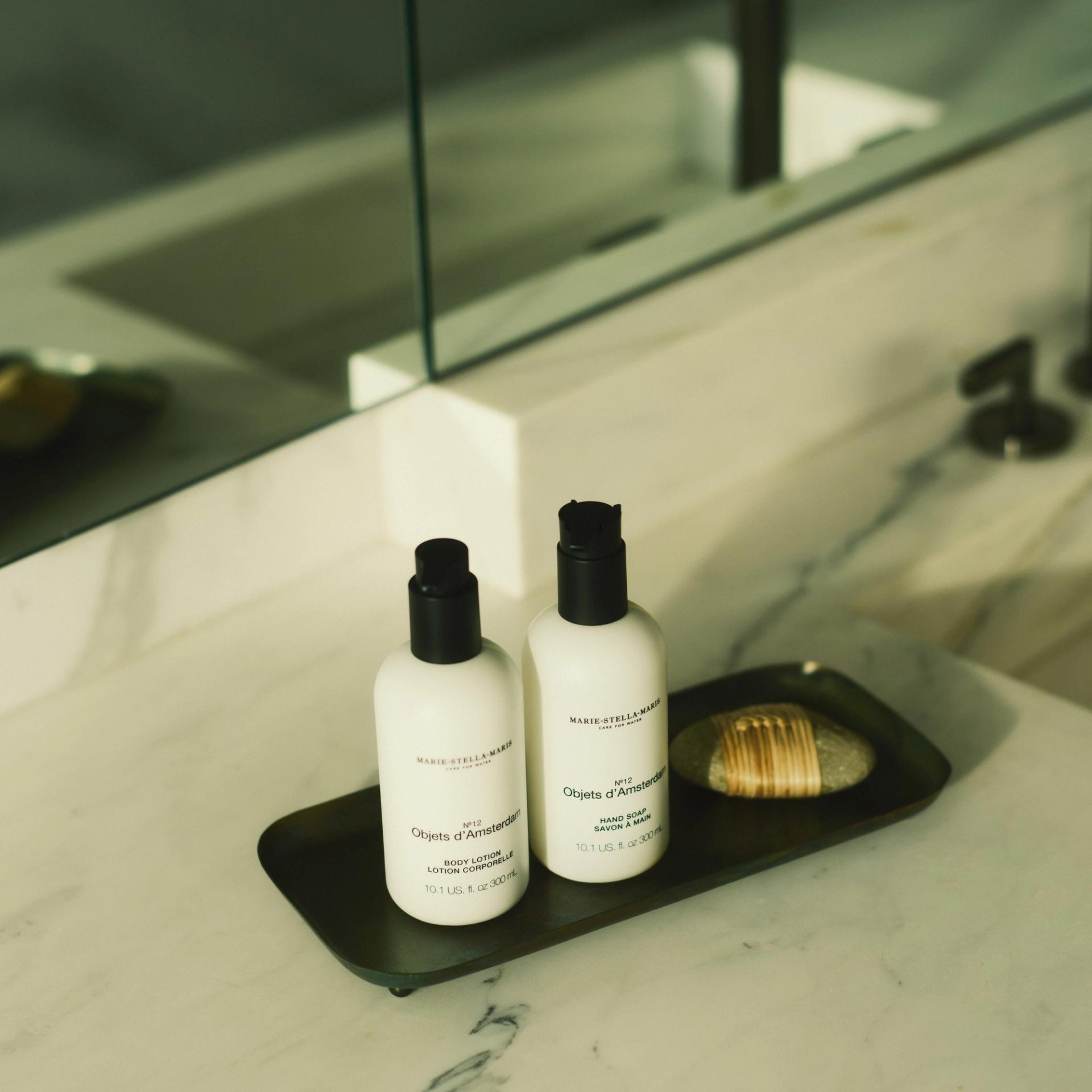 Marie Stella Maris Objets d'Amsterdam Hand Soap and Body Lotion dispensers on marble bathroom vanity