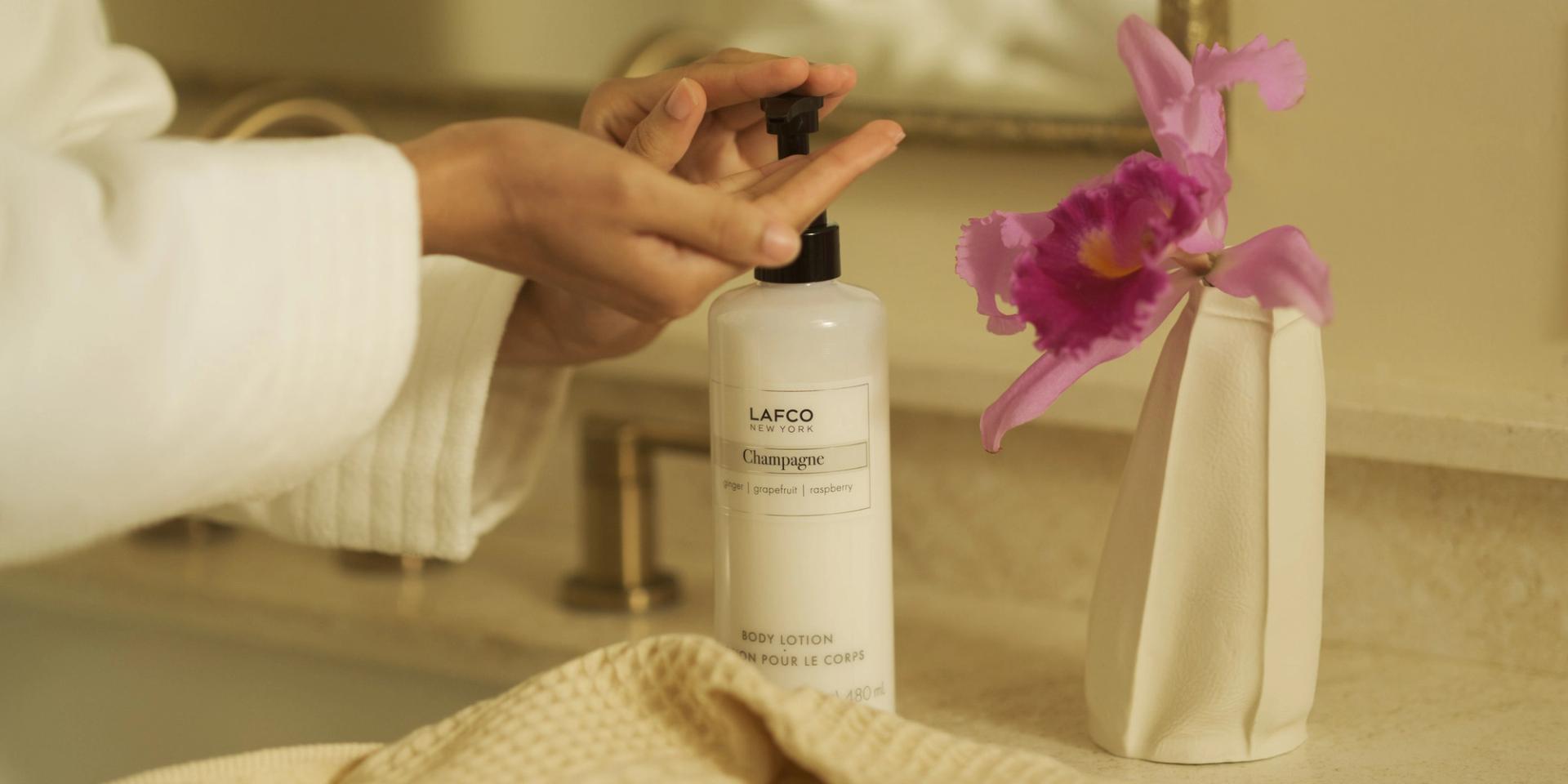 Girl pumping Lafco Champagne Body Lotion onto her hand