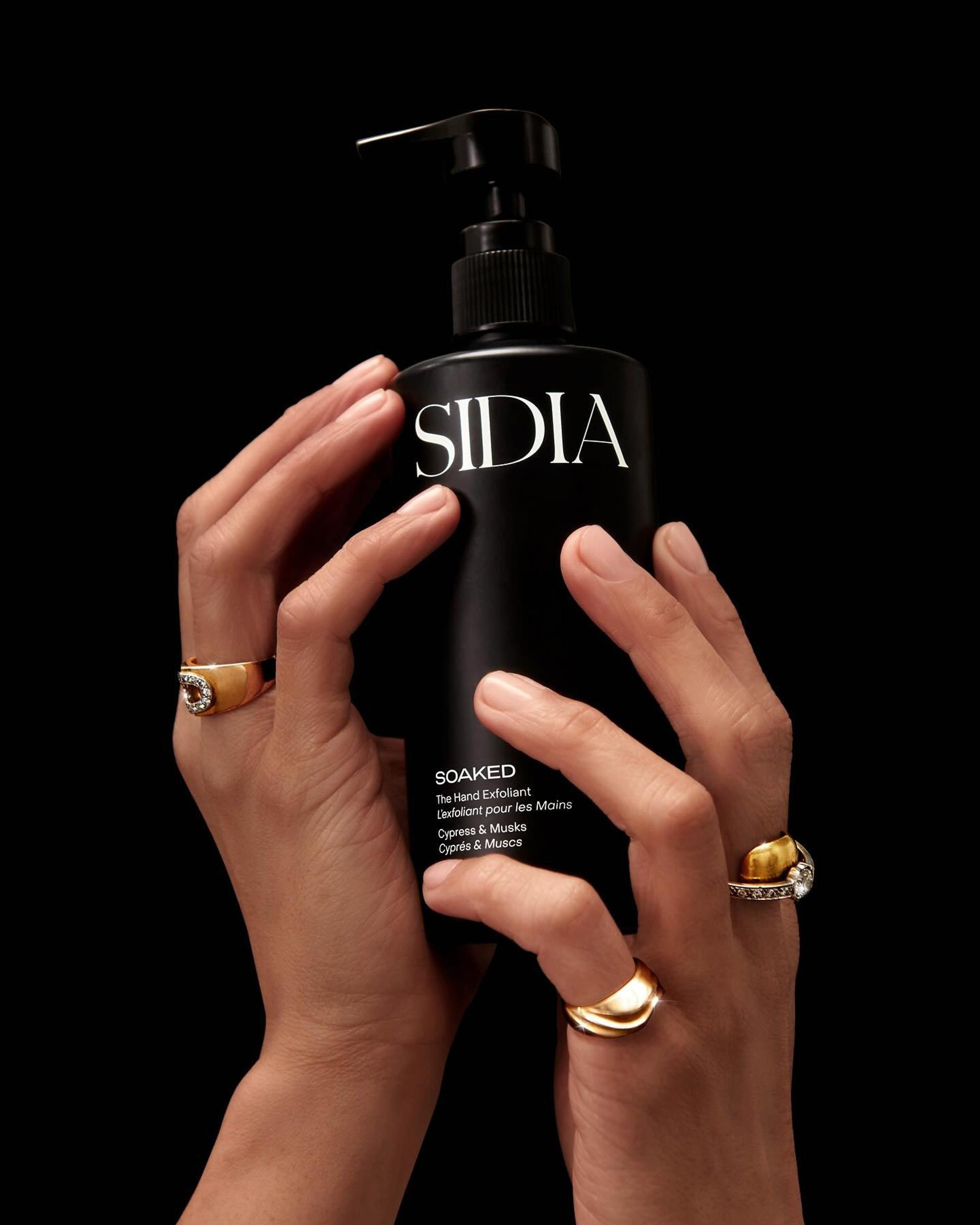 Woman holding Sidia Hand Exfoliant in hands