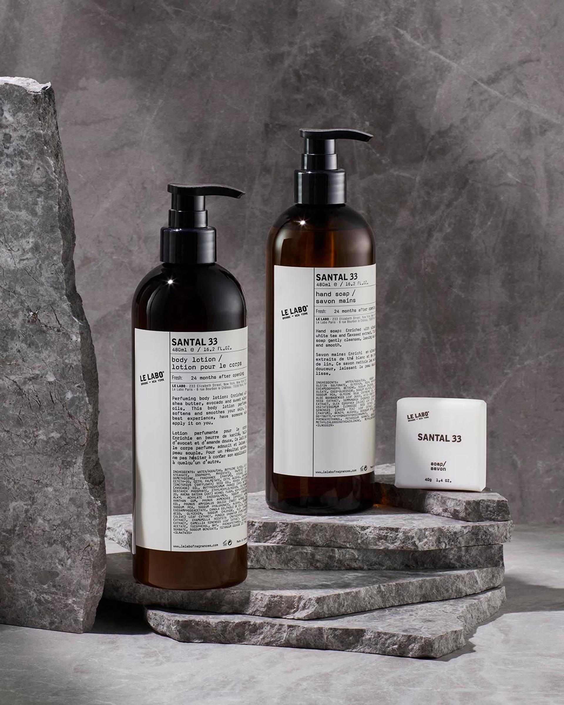 Le Labo Santal 33 Body Lotion and Hand Soap dispensers and Bar Soap on counter with rock