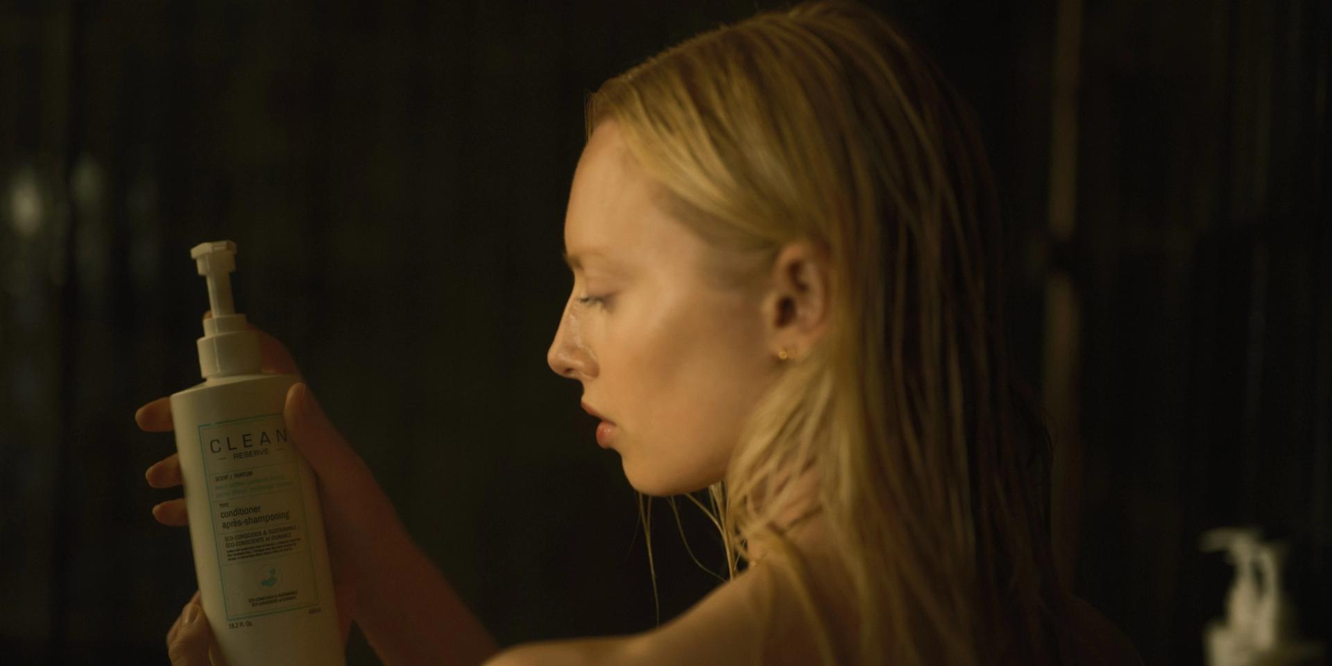 Girl holding Clean Reserve Conditioner in shower