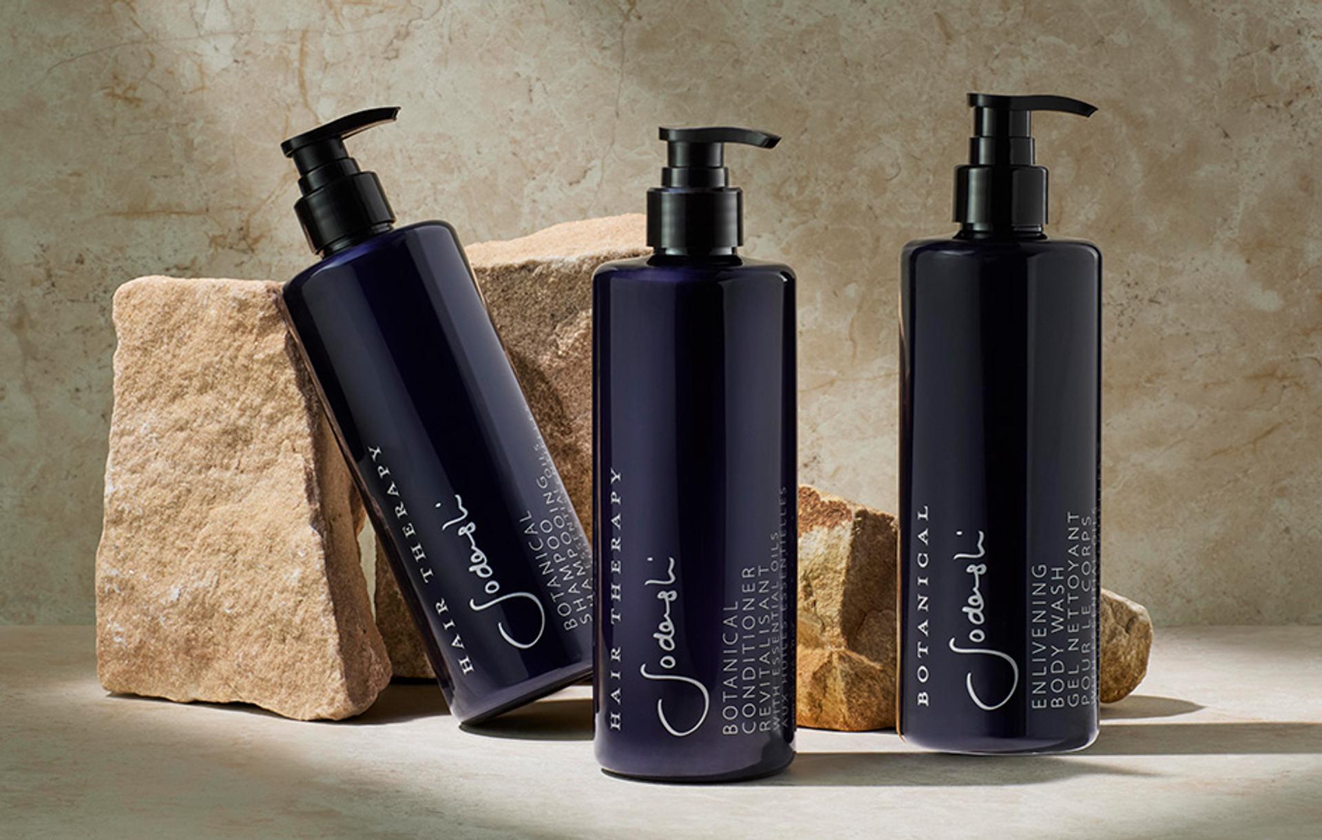 Sodashi Shampoo, Conditioner, and Body Wash dispensers on bathroom vanity with rocks