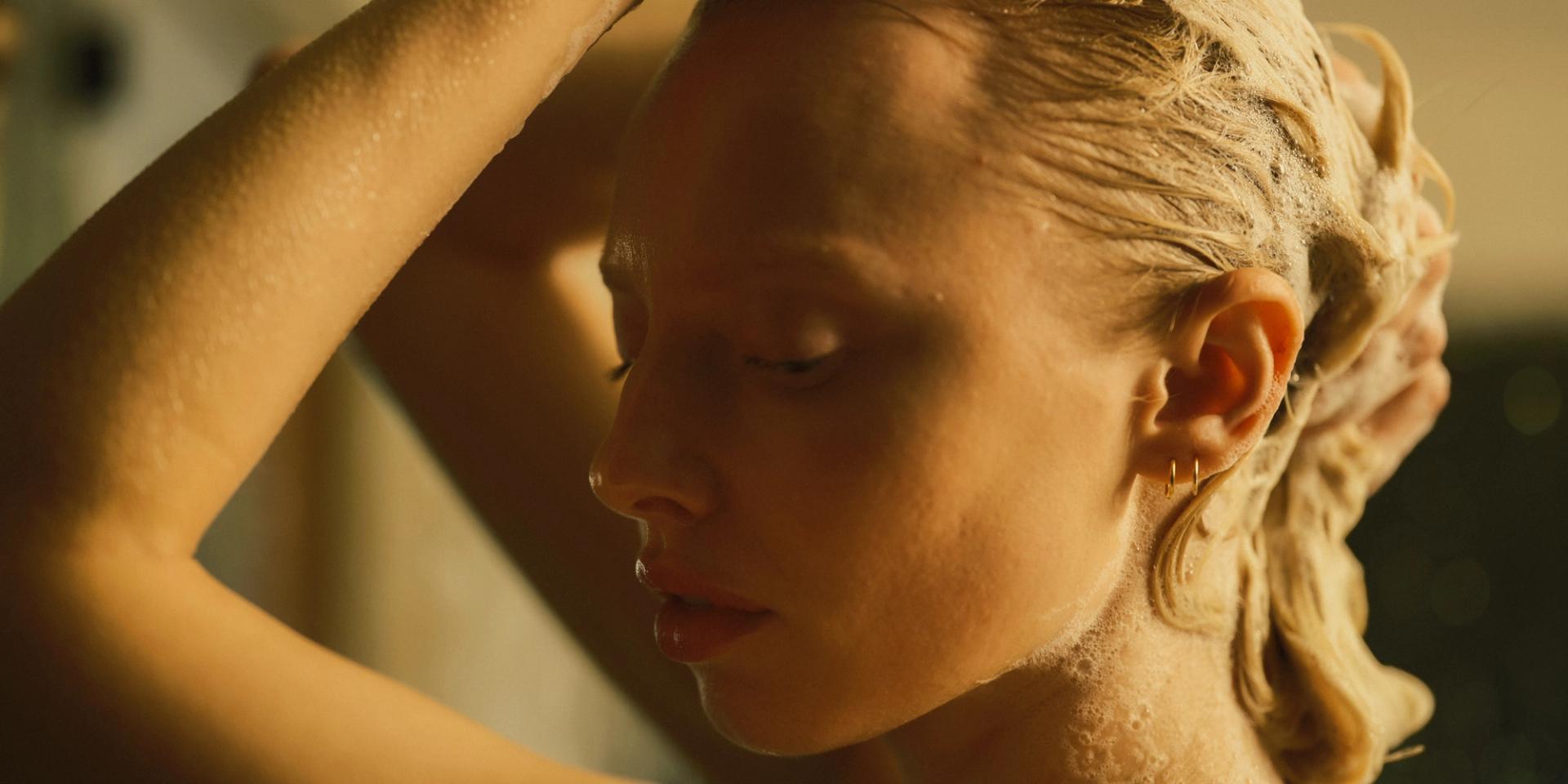 Girl lathering hair in shower