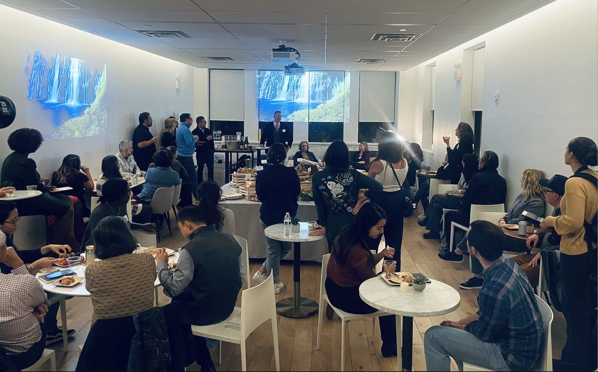 A beautifully lit room, filled with community, feasting and listening together