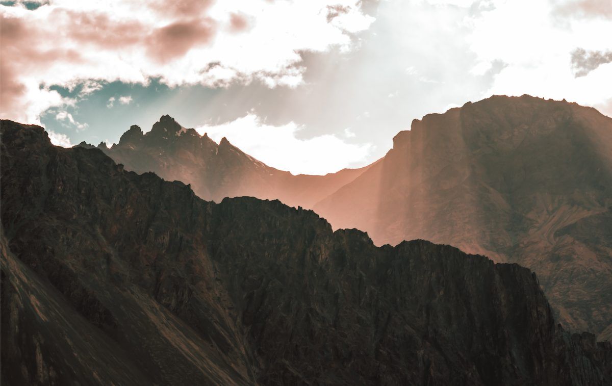 Brown and green mountains under white clouds and blue sky