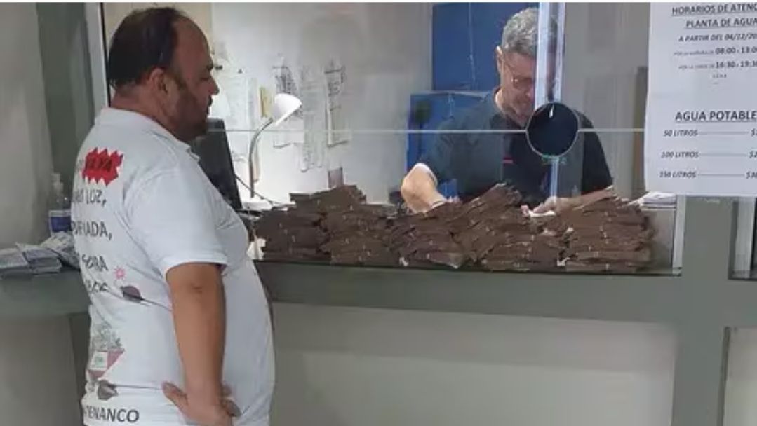 VIDEO: Le vino 840 mil pesos de luz y pagó todo con billetes de 100 y 200 en una carretilla