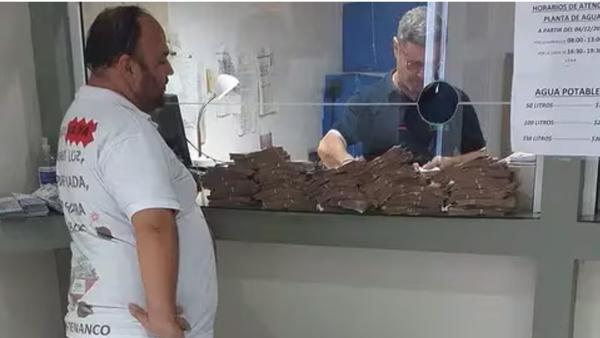 VIDEO: Le vino 840 mil pesos de luz y pagó todo con billetes de 100 y 200 en una carretilla