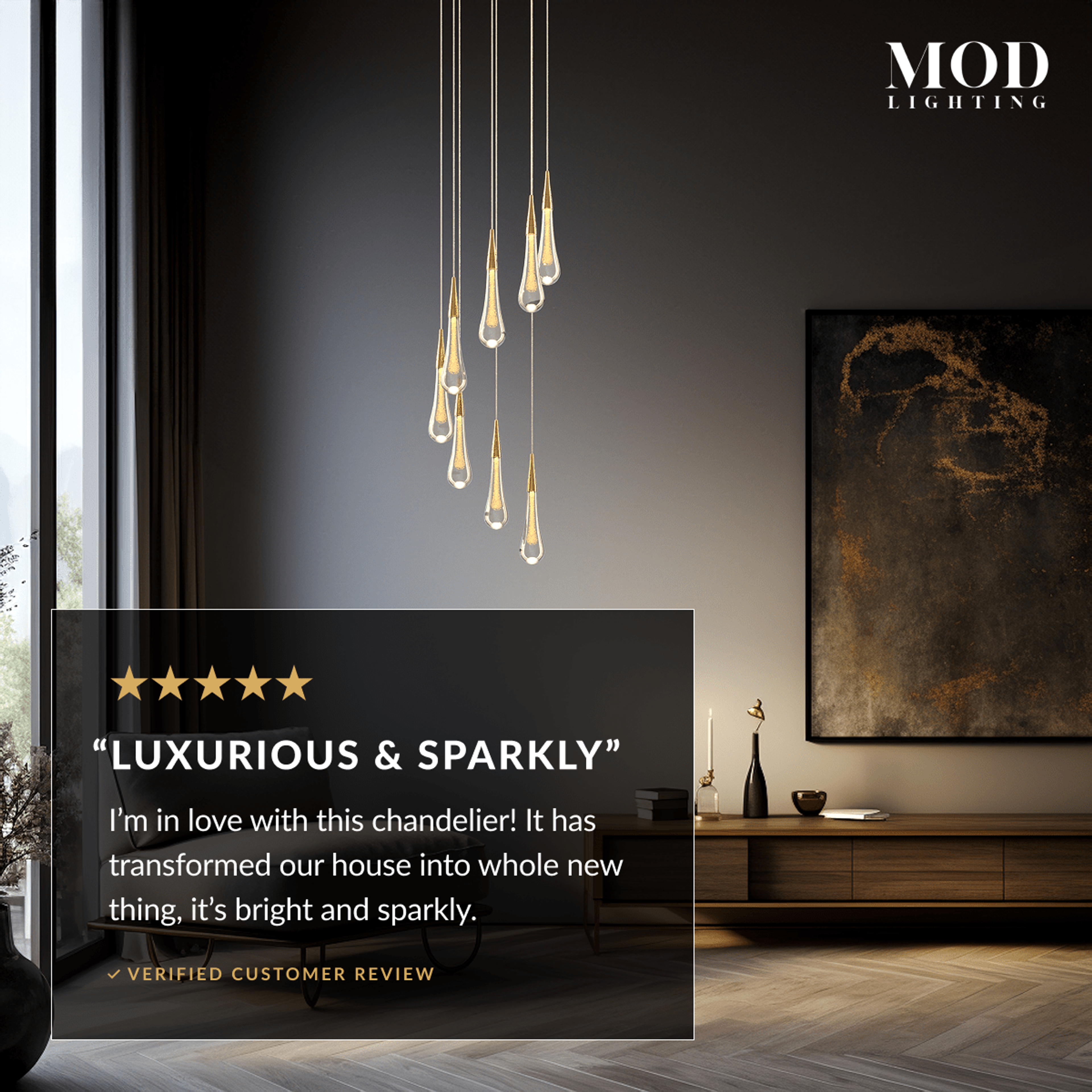 Indra chandelier, cluster of lit gold crystal teardrops suspended in a dark living room