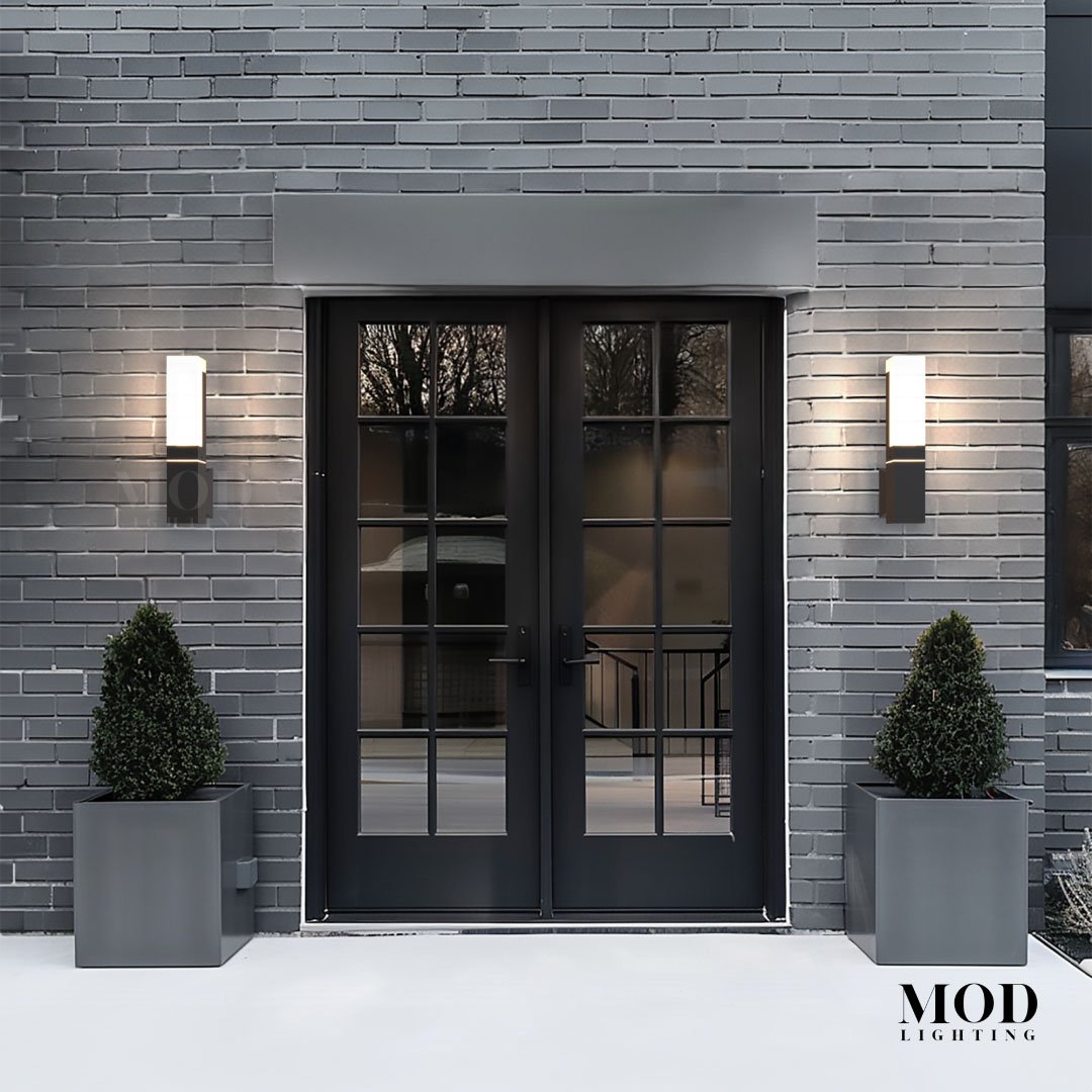 Falcon outdoor sconces, black wall fixtures with warm LED glow, flanking a French entry door