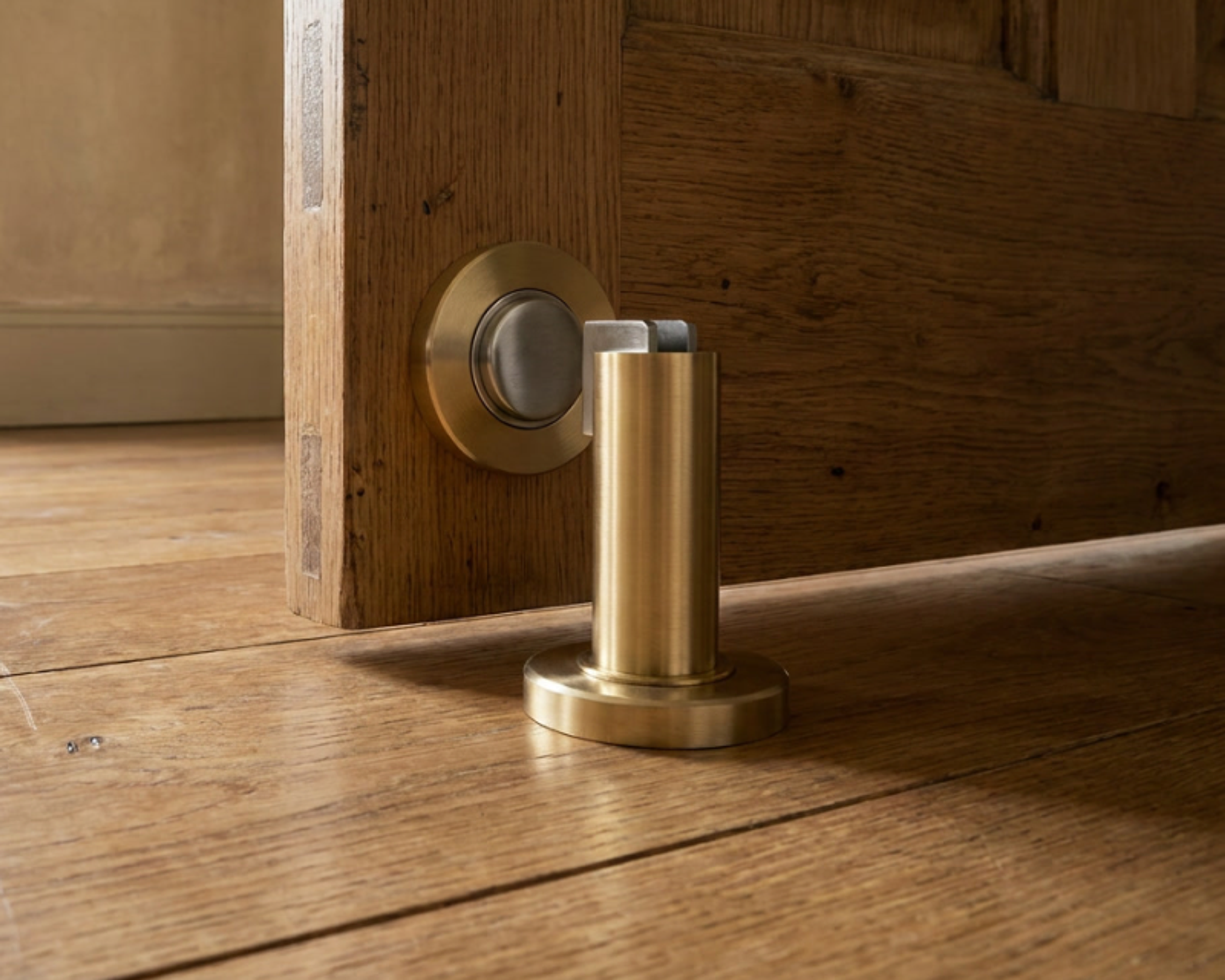 Cavo brass door stop on a beige floor